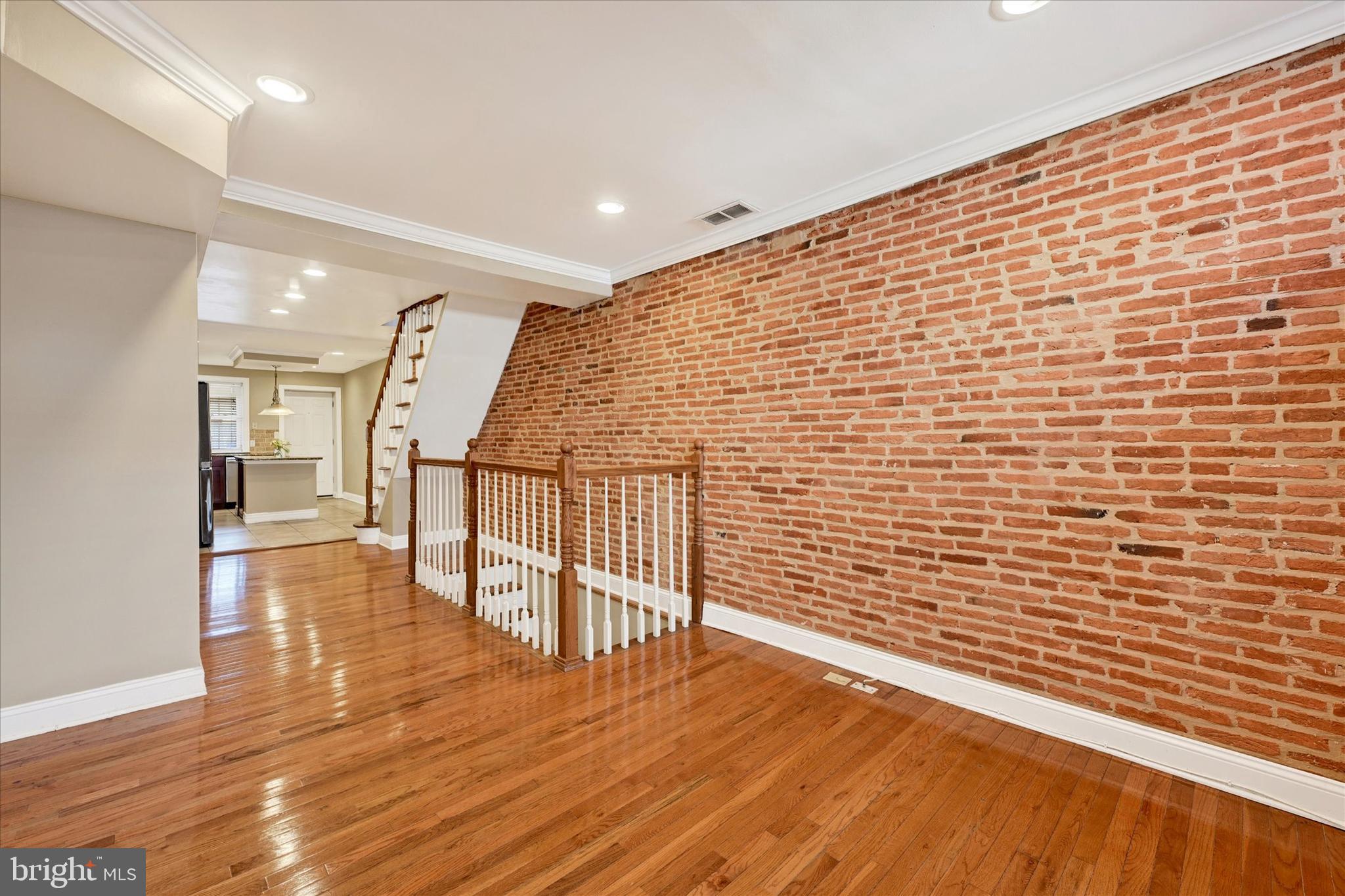 Welcome to 115 N Bradford St – a charming and stylish townhouse located just steps from Butchers Hill! This beautifully updated 2-bedroom, 3-bathroom home blends modern finishes with classic Baltimore charm, featuring hardwood floors and an exposed brick accent wall in the main-level living room. The kitchen boasts stainless steel appliances and plenty of cabinet space. Upstairs, you’ll find two spacious bedrooms, each with its own full bathroom, and access to a private balcony. The finished lower level provides additional living space, a third full bathroom, and a utility room. Enjoy outdoor living on the rear deck and the convenience of a private parking pad. All of this within walking distance to local dining, Patterson Park, and more. Schedule your showing today!