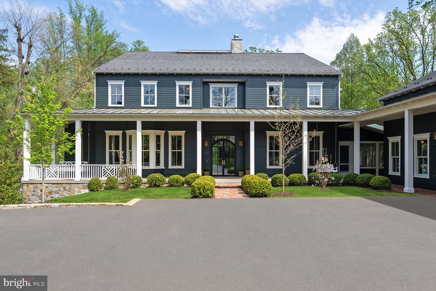 Nestled on 1.5 beautifully landscaped acres backing to 500+ acres of protected parkland, this 2023 custom home blends timeless 19th-century Four-Square design with modern luxury. From the moment you arrive, the home captivates with its charming front porch, featuring classic swings and arched glass entry doors that lead into a striking foyer anchored by an architectural staircase and open atrium, a true work of art. The thoughtfully designed floor plan offers 12-foot ceilings on the main level, arched doorways, and oversized fireplaces. The formal living room connects to a sophisticated office/library complete with a wet bar, while the elegant dining room, enhanced by a cozy fireplace, sets the stage for memorable gatherings. The beautifully crafted Plain English kitchen is a showpiece, boasting top-of-the-line appliances and designer finishes. It opens to the family room and a sunlit breakfast room. A separate media room features a unique “trampoline ceiling,” offering both function and fun for kids and kids at heart.

Upstairs, the luxurious owner’s suite is a private sanctuary with dual walk-in closets and a spa-inspired bathroom with separate vanities. Four additional bedroom suites each enjoy their own private bath, and a convenient upstairs laundry room adds everyday ease. The lower level is designed for recreation and wellness, featuring a one-of-a-kind four-story climbing wall and direct access to the outdoor patio and grounds. Step outside to your own private oasis, complete with a heated saltwater pool enhanced by swim jets and fountain jets, a 64-foot garage-turned-basketball court with finished office space above, and a beautifully appointed pool house with a wet bar and full bath, perfect for guests or entertaining.

Ideally located, this home offers a rare combination of tranquility and convenience, just steps from a 1.5-mile trail to the Potomac River and within minutes of Downtown McLean, prestigious schools, Tysons, and easy access to I-495 and the GW Parkway