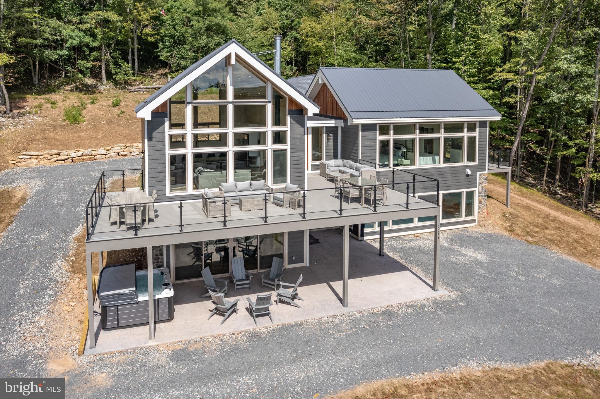 New construction and brand-new to the vacation rental market, Grey Haven is sure to become one of the top income-producing properties in the Deep Creek Lake area! This 7-bedroom, 5-bath luxury retreat features a spacious open-concept design that blends modern comfort with timeless mountain charm. Signature amenities include a private indoor pool, an 8-foot hot tub , expansive deck, and a custom home theater. Adding unique character, the living room is anchored by a one-of-a-kind chandelier crafted from a locally made 1960’s canoe.
Designed with sustainability in mind, Grey Haven is an exceptionally “green” home. Constructed with an ICF foundation and top-grade insulation, it uses no carbon fuels for heating or cooling. Instead, it features advanced heat pump technology, all-electric appliances, dual EV chargers, and a restored vintage Malm wood-burning fireplace—delivering eco-conscious efficiency with average utility costs under $300 per month, even with heating the pool!
Additional upgrades include $10,000 in custom window treatments throughout, a full sprinkler and alarm system, and a TVRU/rental license in place, making this a true turn-key opportunity. Located just minutes from Wisp Resort, marinas, restaurants, and year-round recreation, Grey Haven is the ultimate mountain escape—whether for private enjoyment or as a high-performing vacation rental property.