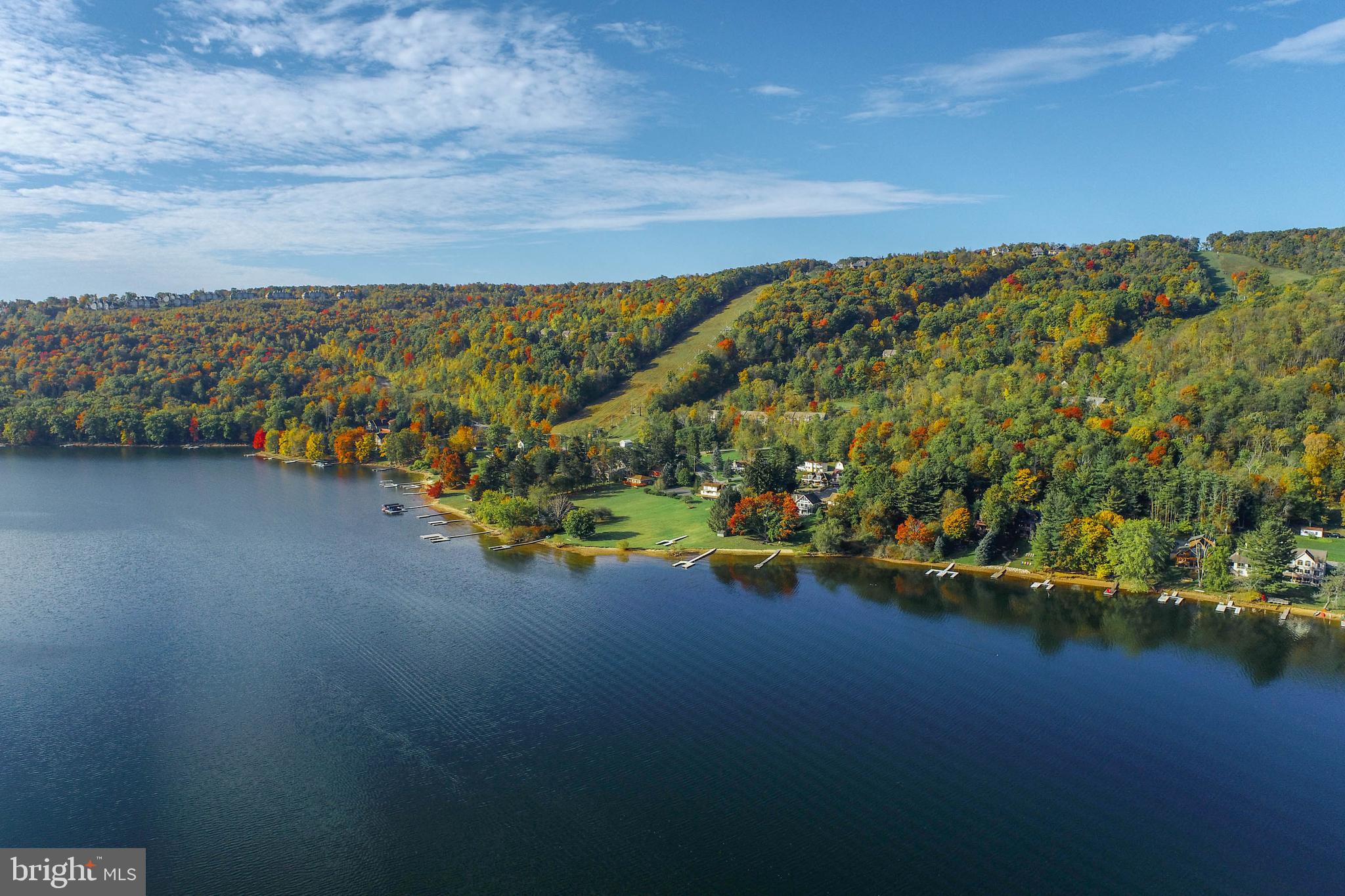 Discover a rare opportunity to own 180 feet of prime Deep Creek Lake frontage along the highly sought-after Marsh Hill Road, just steps from the year-round recreation of Wisp Resort. This unique lakefront property offers incredible flexibility, whether you're looking to build a private estate, develop multiple homes, or invest in a boutique townhome project. The parcel can be utilized as three separate 60-foot building lots, each with its own single-slip Type A dock permit—perfect for individual vacation homes or resale. Alternatively, combine into two 90-foot lots with unrestricted Type A dock permits for larger lakefront retreats, or retain the full 180 feet for an expansive dream home with panoramic water views and ample space for outdoor living.
Adding to its value, the property also includes a quarter-acre lot directly across Marsh Hill Road, ideal for constructing a guest house, carriage home, or additional garage space. With a mostly level approach to the water, utility access at the street, and unmatched proximity to skiing, golf, marinas, and restaurants, this offering combines convenience, natural beauty, and development potential. Whether you're a builder, investor, or dream-home buyer, this is a once-in-a-generation chance to secure premier shoreline on Deep Creek Lake. Don’t miss out—properties of this caliber are rarely available.
Parcels are also available for sale separately.