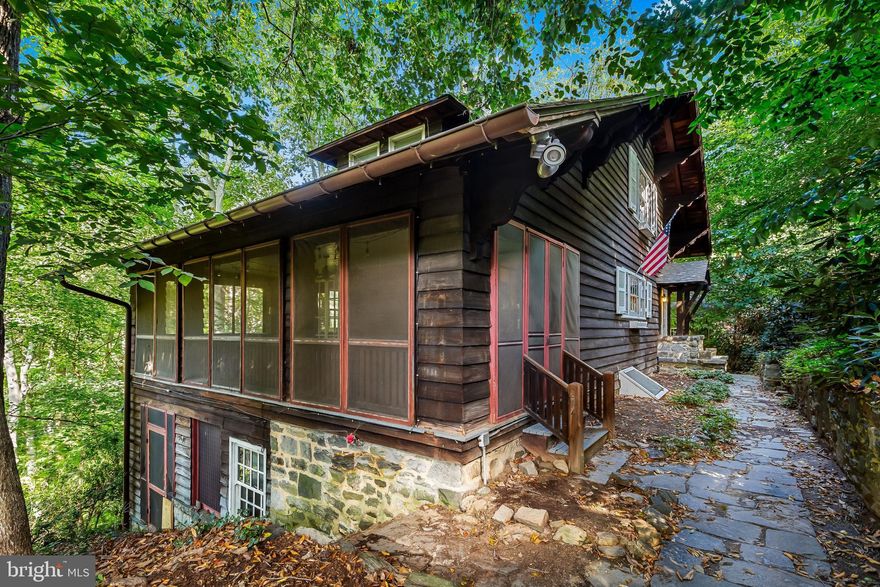 Tucked away close to a cul-de-sac's end, this  Adirondack type cottage , designed by noted architect Edward Palmer, invites you to experience the best of both worlds – a retreat in the trees and the convenience of being just a short stroll from Roland Park's shops and amenities, The entry level has a large living room with wood-burning fireplace along with 2 spacious rooms equally well suited as bedrooms or offices/dens and connected by a full bath. The true highlight of this level is the large screened porch with hardwood floors - just imagine listening to birds in the mornings and owls in the eve!  Down a flight of craftsman style stairs, you'll discover a large dining room and kitchen along with a powder room, butler's panty and family room. The top floor boasts a large primary bedroom, an additional bedroom and full hall bath. An important feature of the property is undoubtedly the  stone staircase that leads from the street  to the front entrance, adding character and a touch of adventure to this delightful abode! Priced to allow for improvements, don't miss the chance to make this charming house your new home.
