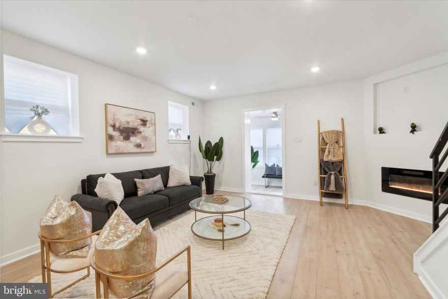 Welcome to this beautifully rehabbed end of row home located in the heart of Southwest Philly. Perfect for modern living, the home boasts an open floor plan incorporating sleek, upscale finishes throughout. The spacious kitchen is a chef's dream, featuring a pantry, gorgeous subway glass tiles, a touchless faucet with a pull-down spray feature, and subtly veined quartz countertops. Enjoy the elegance of white shaker cabinets with soft-close mechanisms and stylish champagne gold hardware. For communal dining, the kitchen offers island seating for four under the glow of beautiful pendant lights, all enhanced by the addition of crown molding for architectural flair. The home is equipped with high-efficiency central air and heat and boasts pocket doors and wrought iron railings. Ceiling fans in the bedrooms and dimmable LED lighting contribute to a customizable comfort experience. The primary bathroom impresses with oversized ceramic floor and wall tiles and is equipped with a tub featuring both a rain head shower and handheld options, as well as a touch LED mirror for added convenience. An additional first-floor powder room and a second full bath provide practical solutions for a busy lifestyle. Storage is ample with a hallway linen closet conveniently placed next to the laundry hookup. Throughout the home, you'll find SPC luxury vinyl flooring, new windows, roof, electric, and plumbing—all part of a comprehensive renovation. This corner property offers an enclosed porch/sunroom ideal for relaxation. Enjoy the cozy feel of a remote-controlled electric fireplace in the living room. The finished basement with walk-out features a full bathroom with rain head and handheld shower. Situated just minutes from University City, Center City, and Philly International Airport, this home offers unbeatable convenience and is ready for its new owners. This home qualifies for more than $10,000 in first time homebuyer grant funds with select lenders, so don't miss out! Schedule a tour today!