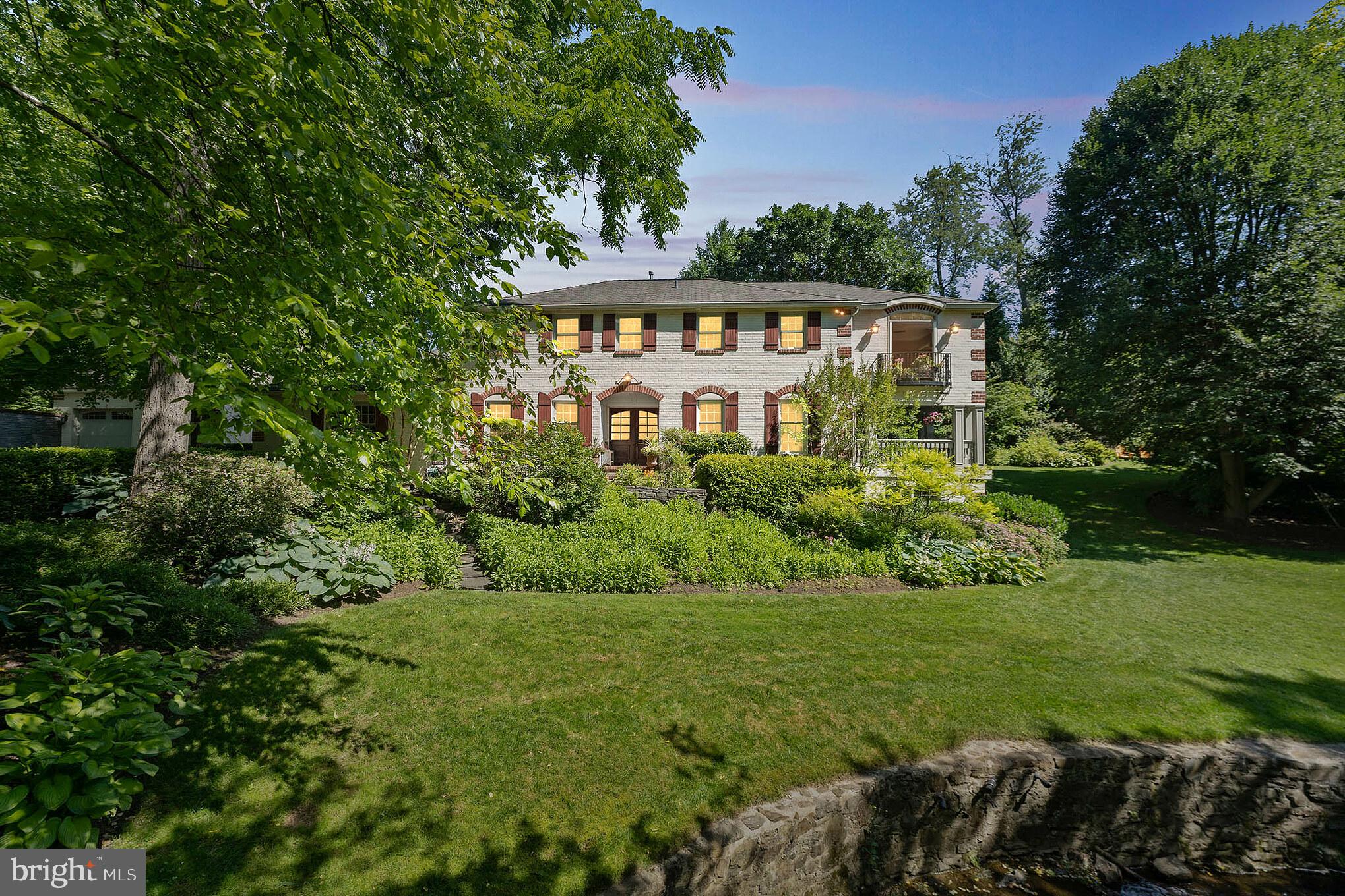This French-inspired updated colonial, tucked away on a private lane and adjacent to a park in the estates section of St. Davids, is just a short walk to downtown Wayne. The open floor plan—ideal for today’s lifestyle and perfect for entertaining—includes a chef’s kitchen that adjoins a great room with a vaulted ceiling and fireplace. The elegant and open living and dining rooms feature a fireplace and a wall of French doors that lead to a gracious porch overlooking a private setting complete with lush landscaping, a babbling brook, and a magical stone bridge. A powder room, mudroom off the kitchen, and library with floor-to-ceiling built-in bookcases complete the first floor. Head up the staircase and take in the back garden with pond and waterfall, beyond which are bucolic views of the grounds of two grand Main Line estates. Enter the primary suite which includes a dressing room with custom closets and a large spa bathroom. A “Juliette balcony” in another of the bedrooms adds to the home’s unique brand of sophisticated charm. The home offers 5 bedrooms, 3 full baths, 1 half bath, and an upstairs laundry room. A finished, walkout lower level offers additional living space, an exercise room, guest quarters, and a fun space for movie-watching or shooting pool. Located in a beautiful neighborhood reminiscent of the Main Line of yesteryear, this lovely home is but a stroll to Fenimore woods and pond, Wayne and St. Davids train stations, award-winning Radnor schools, public library, and many fabulous restaurants and shops that are a hallmark of the wonderful town of Wayne.