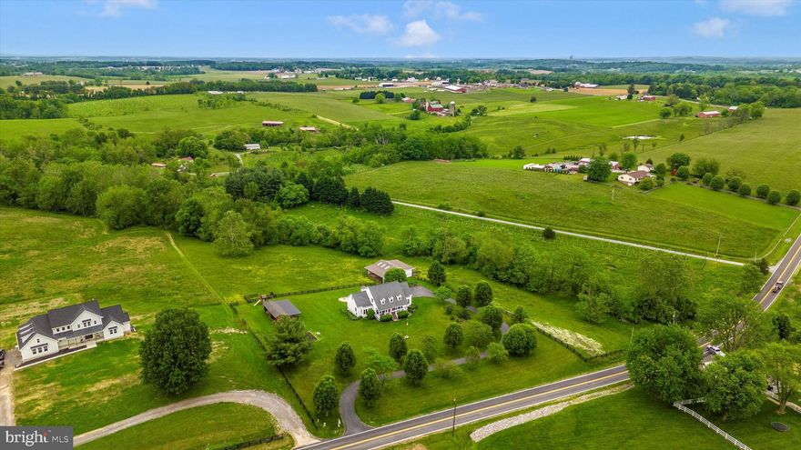 Turnkey perfection in the heart of the sought after and incredibly desirable Union Bridge community. TWO barns, paddocks and VIEWS for miles.  This desirable property is secluded from the hustle & bustle yet convenient to all major arteries. This farmette finds itself less than 45 minutes from the major metropolitan areas.   This impeccable estate is just under 10 acres featuring a gorgeous custom designed Creole Cape Cod of timeless quality construction -2 x6 exterior construction, 9 1/2' ceilings, 50 yr architectural shingles, solid oak hardwood floors as well as all new appliances in 2022.  The heart of the home features a spectacular gourmet light filled kitchen perfect for the in home chef or entertaining with ease on a larger scale.   In the kitchen, you'll enjoy picturesque granite countertops, rich designer cabinetry, a wall oven including a microwave/oven combo, electric induction stovetop with convection oven and a retractable downdraft fan.   A short walk through the dining room, family room with cozy fireplace and formal living rooms and you've reached the main level primary bedroom.     The relaxing primary bath is the embodiment of luxury with a programmable heated tile floor, stacked stone wall, luxe fireplace and clawfoot cast iron soaking tub. A walk in shower with dual shower heads, private water closet and Bluetooth speaker adds to the reserved level of ambience . The cathedral ceiling with skylight and spacious walk  in closet offers tremendous additional space. The cozy propane fireplace is the focal point of the family room that opens to a brand new outdoor deck space and continues onto the expansive low maintenance composite deck.  The walkout lower level features deep plush theatre seating and movie room, media closet and den/office.   In addition to brand new appliances, the new owners will appreciate a dual hot water heater system that provides consistent hot water to the entire household. The winding driveway is lined with fruit and flowering trees that add beauty to the mature landscaping around the home which is encased with perennial flower beds, mature shrubs and a grape arbor. 4 board oak and high tensile solar electric fencing and access to the meandering Isaiah Creek add perfect turnout for horses, cattle, llamas or the livestock of your choice.  2 barns, a chicken house with an enclosure are situated on several paddocks creating perfect rotation and turnout.  The sellers kindly share and offer their 2- custom constructed raised garden beds, a greenhouse, a large firepit, a 2 person sauna and a brand new children's playset to provide hours of activity and at home enjoyment.  This one of a kind custom estate home in the heart of Frederick County's tranquil countryside is a total luxury package with a list of must haves that simply will not last.