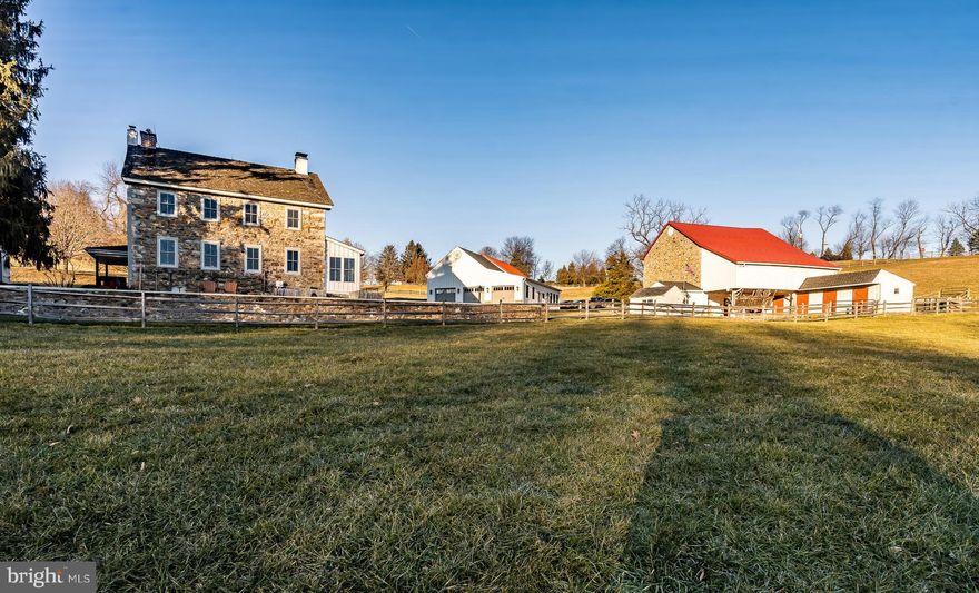 This beautiful farm is nestled in a hollow, with a light, bright, antique stone home, a historic barn, and 4 outbuildings, all set on 18 rolling acres. The date stone on the home states 1833 but the oldest part of the home has been researched to be c.1798. The fabulous stone bank barn’s date stone states 1819 and was constructed by a veteran of the War of 1812! The current owners have done a magnificent job of staying true to the home’s original historic heritage while also installing designer magazine worthy modifications including a new gourmet Kitchen complete with high end stainless Thermador appliances including a steam convection oven and a state-of-the-art coffee maker – both set in beautiful custom cabinetry that features two large pantry cabinets. You will love the Kitchen’s easy care but period correct brick floor and stunning live-edge English walnut island countertop. The Living Room features random width wide-plank floors and the home’s original cooking fireplace with its grand opening and original wrought iron crane. The windows include curved plaster work and deep windowsills making this a bright room with a priceless view. The other end of the Living Room displays a handsome corner fireplace with a super-efficient and beautiful wood burning insert. Off the Foyer is a handy Powder Room and the Kitchen access with the Laundry conveniently located off the Kitchen.  Walk outside through the Kitchen’s French doors to find a large covered porch that is a perfect place to entertain friends and family. A second covered porch is on the west side of the home and is an ideal location for the grill and a quiet drink on a summer afternoon. Rounding out the rooms on the main level is the Office with a charming corner fireplace and a window with original period moldings. Upstairs is a wonderful Master Suite, with a sumptuous marble Master Bathroom, another added feature the owners installed and could also grace the pages of a designer magazine. There are three additional bedrooms with gorgeous views and a charming vintage Hall Bath. Behind the house is the farm’s original well-maintained Summer Kitchen, a favorite spot for outside parties.  The large Three Car Garage was added on to an early stone barn which retains many of its original historic features and creates additional car parking - a great feature for the car collector! Attached to this building is a comfortable Guest or In-Law studio apartment with a private bathroom, Kitchen with GE appliances, and a pellet stove that gives cozy warmth. The large barn has nine box stalls plus a wash stall and a separate tack room with powder room. The voluminous loft area of the bank barn is in magnificent condition with newer floors and electric, great for a studio, a giant kids play-space or your next big party. There are six pastures in total, three on each side of Veronica Drive with well-maintained split rail fencing and an additional 24 x 24 barn with 2 box stalls on the 8.2 acre parcel across the street. The versatile agricultural uses are up to you with an indoor arena permitted on the 8.2 acre parcel but not an additional residence. Further enhancing the farm is an established 40-tree fruit orchard and over 300 Christmas trees. This property has been exceedingly well maintained with a recently installed cedar roof on the house and newer roofs and electrical on all the outbuildings.  Convenient to Route 401 and 113 as well as major corporate centers, this home represents an excellent value and a wonderful opportunity for the discerning buyer.
