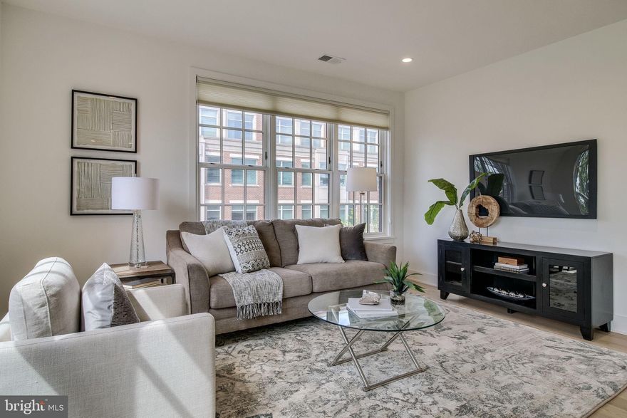 Refined Living in Old Town Alexandria! Welcome to the Bottling House: built-in 2017, this unit features an open concept layout with high ceilings, gleaming wide plank engineered wood floors, designer lighting, and fixtures throughout. The serene living room and dining areas create an inviting feel to the unit with high ceilings, city views, and loads of natural light. The gourmet kitchen offers crisp quartz counters, an expansive peninsula, and Bosch appliances, complete with a gas range. The master bedroom offers a peaceful retreat, with a spacious closet complete with custom organizers, and a spa-like master bathroom with dual sink vanity and designer tiled shower. The second bedroom offers floor to ceiling windows, a large walk-in closet, complete with an en-suite bathroom with a large vanity, and a shower/tub combo. Full-sized stacked washer/dryer. The elevator from the garage & building entry opens directly into the unit! Secured garage parking conveys. Ideal location! Minutes to the waterfront, parks, around the corner from Trader Joe's, and blocks to a plethora of retail and restaurants on King St! Perfect for commuting to DC, Pentagon, Crystal City, and Reagan National.