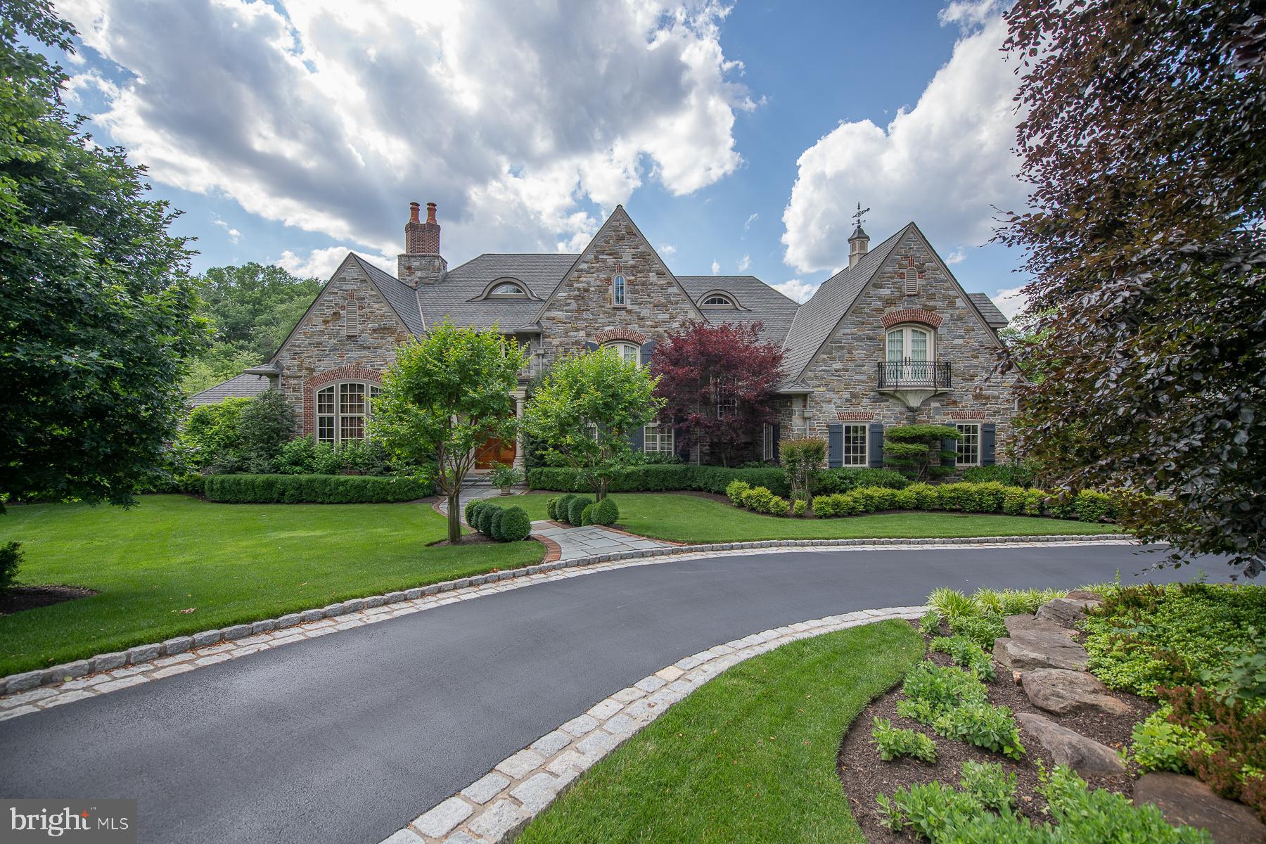 It's all in the details of this stunning custom ten year old estate set on the quiet cul de sac of Winfield in Devon. 2.7 acres of magnificent fenced in grounds featuring lovely English style gardens. Historic Spanish cedar doors welcome you into the elegant view through Foyer with balcony overlooks. Hand hewn wide plank hickory floors grace most of the first floor. The formal dining room is adorned with Felber plaster molding and deep paneled archways. A Library worthy of the Earl of Grantham was constructed by Jonathan Trueblood stands off of the foyer with majestic 14 foot ceilings, California Elm wall and ceiling moldings, and an English fireplace. The first floor gallery has wood wainscoting and leads to the dramatic Grand Room with 22' high coffered ceilings, Felber plaster moldings, a hand carved TV cabinet, a piano alcove and Francis Purcell antique mantel. Two sets of french doors lead to a flagstone Loggia. Here you'll find an outdoor cooking space, a stone fireplace, and stone balusters overlooking the grounds. The Coventry Kitchen has all the modern amenities with its Gagganau Steam oven, convection oven, and warming drawer, Thermador six burner rangetop with griddle, Miele dishwasher, stainless microwave, and paneled Subzero refrigerator and freezer drawers. The tiered island features a bridge faucet and farm sink. A built in banquette, lighted hutch, and bookcases frame this inviting space. Treat yourself to a cappuccino with a built in Miele coffee station in the Butler's Pantry which includes a dual temp wine chiller. A four stop elevator makes getting yourself or your things up and down with ease. Off of the Kitchen is a sunlit desk with windows overlooking the gardens. The morning room is a warm space with bead board tray ceiling and opens to the Loggia. The Kitchen wing is finished with a walk in Pantry with a Thermador fridge and cherry cabinets. The convenient Laundry Room has designer tile wainscoting, a built in ironing board, hanging rack and plenty of cabinets. There is also a full bath on this level in addition to the formal powder room. A Georgian style second staircase with picture window leads up to a charming reading loft. At the end of the first floor gallery is the Master Suite. An anteroom opens into a relaxing sitting room with outdoor balcony. The Master Bedroom features a tray ceiling with lovely moldings, and two walk in closets with built in full length cabinetry. Luxuriate in the Master Bath with two onyx top vanities, built ins, corner tub, walk in shower and domed mother of pearl ceiling. The main staircase is as grand as the room it overlooks with Ironworks railings and three balconies. Upstairs you'll find four generously sized bedrooms, each with its own en suite bath. Bedrooms feature window seats, Juliet balconies, and walk in closets. The third floor has a huge finished space with dormers and plenty of storage space. There's no reason to leave home with the fabulous finished lower level! Your very own movie theater features reclining leather chairs and large screen. The Family Room has a stone raised hearth fireplace and tall French doors out to a huge covered porch. The Bar/Kitchen has custom Sherman Gosweiler cabinetry and Emily Seldin stained glass windows. A working Office is also on this level with cherry coffered ceilings, wainscoting and glass door built-ins. There is also a Playroom, a bright Exercise Room as well as a Holiday/Craft room with floor to ceiling cabinets and counters. A marble powder room and cedar lined room and a spacious veranda complete this level. Step out to the lush gardens and the red Japanese bridge beneath the trees encourages a reflective space. Cobblestone courtyard and garages for 5 cars include an upstairs storage space and whole home generator. Fill your days with friends and family in this warm and welcoming home with exquisite finishes. Your new home awaits; call now to arrange for a private showing!