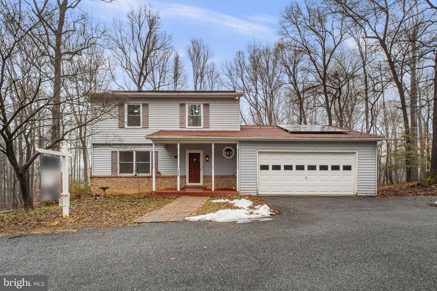 Thoughtfully priced with its condition and distinctive setting in mind, offering great potential for customization.Charming Colonial residence offering 4 bedrooms, 3.5 bathrooms, 2,365 finished square feet, and a 2-car garage, nestled on over two and a half tranquil acres in desirable Covers Corner. An asphalt driveway leads to the welcoming front porch, setting the tone for the home’s classic appeal. Inside, a traditional floor plan unfolds with luxury vinyl plank flooring throughout the main level. The foyer opens to a spacious living room that flows seamlessly into the formal dining room, creating a comfortable layout for everyday living and entertaining. The charming eat-in kitchen features stainless steel appliances, including a refrigerator installed in 2022, vibrant mosaic tile backsplash, stylish cabinetry, a pantry, ample counter space, and a cozy breakfast area with sliding door access to the exterior. Open to the kitchen is the inviting family room, highlighted by plush carpeting and a wood stove framed by a striking floor-to-ceiling brick surround. A conveniently located powder room completes the main level. Upstairs, the primary suite offers a comfortable retreat with carpeting and a private attached bathroom featuring beautiful tilework and a glass-enclosed shower. Three additional bedrooms and a second full bathroom complete the upper level. The walk-out lower level expands the living space with luxury vinyl plank flooring throughout the recreation areas, a third full bathroom, a versatile bonus room with a walk-in closet ideal for guests or a flexible living space, and a laundry room (washer and dryer 2024). Additional updates include HVAC (2025). Outdoor highlights include solar panels added in 2024, a large deck overlooking the peaceful wooded lot, complete with a charming footbridge crossing a scenic creek—creating a private, nature-filled setting. Ideally located in Covers Corner, the property offers a sought-after setting with convenient commuting access to Baltimore, Frederick, and Washington, D.C. *Select photos include virtual staging for illustrative purposes only.
