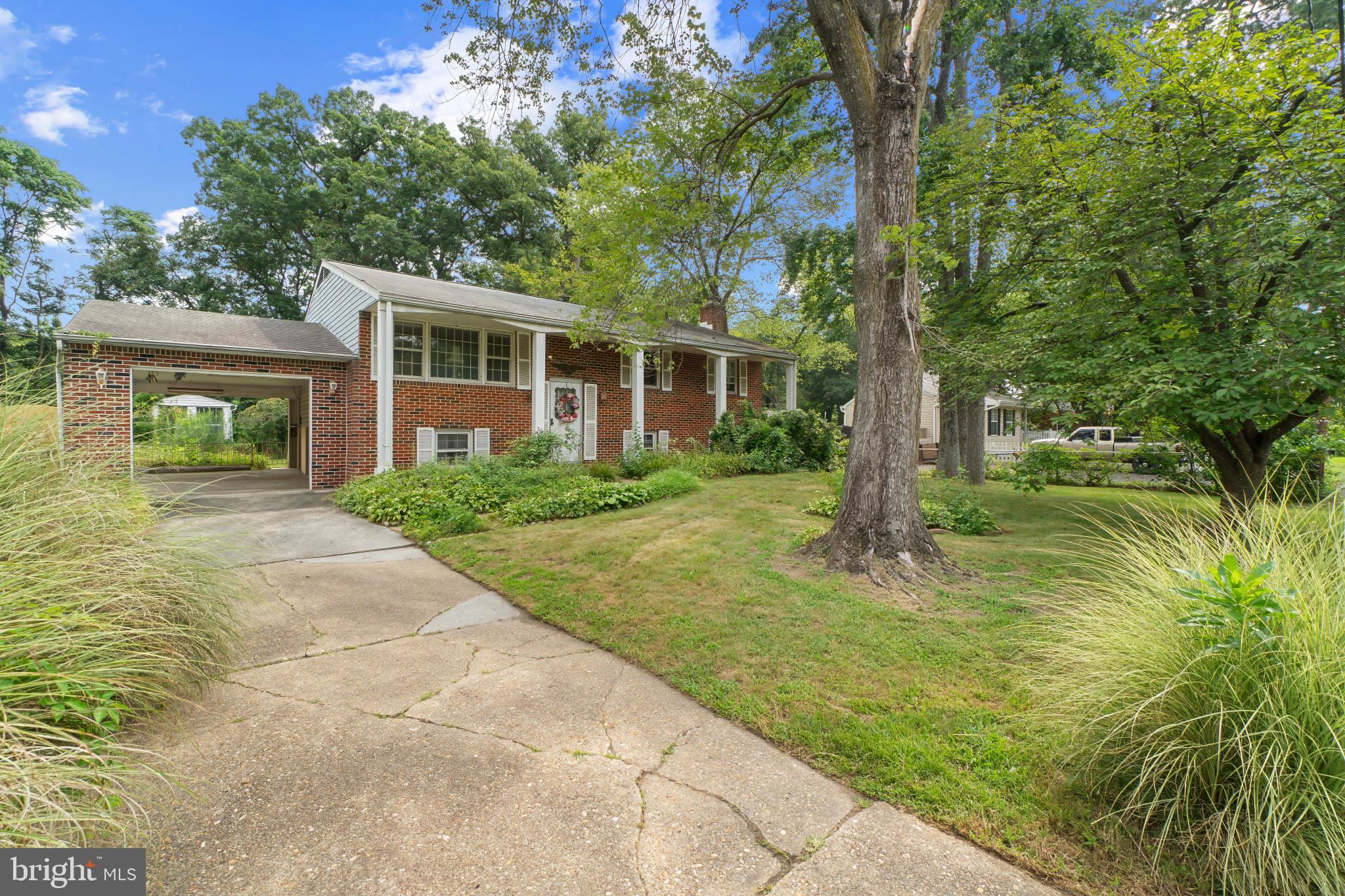 Spacious Split Foyer with brick front offers an oversized carport and is located on over 1/4 acre private level lot. Updates include a newer roof, newer HVAC system and vinyl siding. This home has a large living room, separate dining room with access to the wood deck, and full bath in the hallway that has an opening to the primary bedroom. There are two additional bedrooms on the main level. Additionally, it is good to know that there are hardwood floors under the carpet on the main level. The lower level has a huge recreation room with a wood burning fireplace, two more bedrooms, a half bath and a Utility/Storage/Laundry room that has a laundry tub plus lots of built-in cabinets and shelving. From the lower level you can access an outside stairway to the backyard. The list price reflects the TLC needed. Easy access to major highways, Baltimore, Annapolis, shopping and restaurants.