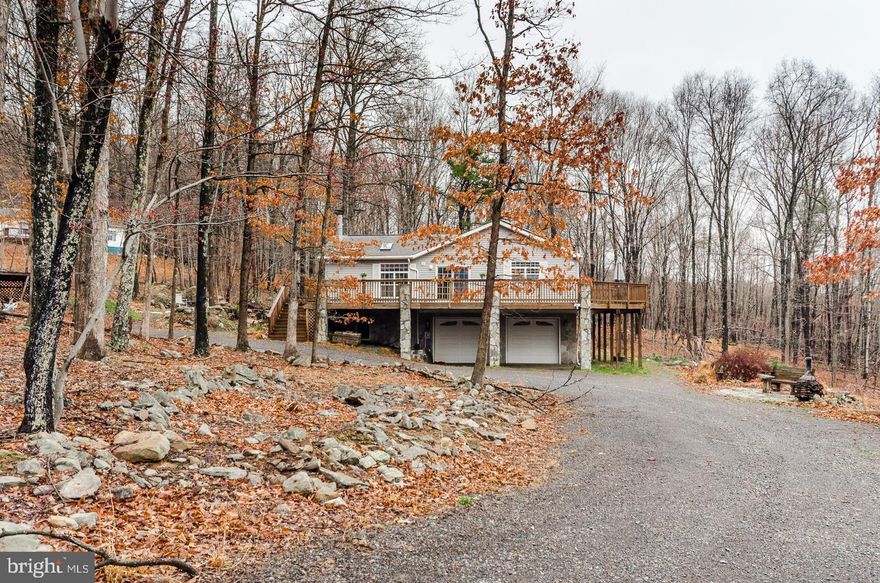 Just reduced! Motivated Seller! Beautiful serene wooded mountain retreat with stocked Koi pond and lots of outdoor space for entertaining situated on more than 2 acres in the gated community of Somerset in Paw Paw, WV. This spacious three-bedroom open-concept home boasts lots of natural light with more than 2,000 square feet of one-floor off-the-grid living that includes raised garden beds and deer fencing surrounding property. Home features large living room with wood burning fireplace and separate family room with wood burning stove as well as upstairs laundry, and whole-house solar powered battery back-up system originally purchased for $68,000. Unfinished walk-out basement (nearly 2,000 sf) includes attached oversize 2-car garage, separate finished Billiards room and plumbing rough-in for additional finished space in the future. Property also features onsite water/electric hookup for RV. Annual memberships are available for access to adjacent Avalon Resort, which features vacation condos, lodge, an aquatics center, as well as camping. Just two hours from DC area, 40 minutes from fabulous shopping and restaurants in Winchester, VA, and 30 minutes to the historic spas of Berkeley Springs, WV. This home is part of a family-friendly clothing optional community. Come check out this unique property on Wild Apple Lane and find out precisely why West Virginia is considered "Almost Heaven."