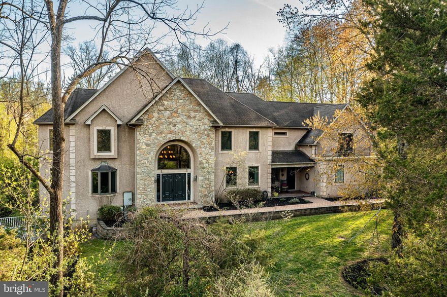 Welcome to this magnificent home nestled in the heart of Worcester set upon a sprawling treed 5 acre lot. Experience the scenic driveway with a babbling brook, stream, and your own private bridge to a slice of paradise. Situated in the prestigious Methacton school district and just around the corner from 2 local Golf courses, Evansburg State Park, and the quaint town of Skippack where convenience meets tranquility at your doorstep. This stately residence boasts breathtaking views and impeccable craftsmanship.  With 4 bedrooms on the second floor and a 5th bedroom on the main level, along with 3 full baths, 2 powder rooms and a first floor home office, every detail has been perfectly planned. Entry from the double exterior doors into the impressive 18 x 17, 2 story Grand foyer with a huge circle top window that offers stunning views of the property and the interior of the house from the 2nd floor circular staircase.  Completely custom built home offers an entertaining floor plan with an open concept starting with the fabulous 2 story family room has a 2 sided fireplace that is also accessible in the kitchen breakfast room area.  This gathering area with 4 huge windows above opens into a lovely sunroom with floor to ceiling casement windows and just beautiful views of the rear garden and patio. The 1st floor has 9 foot ceilings to add to the magnificence of the huge kitchen with not only a large fireside dining and breakfast room but also has a 19 x 16 entry foyer area accessed from the covered cozy front porch with another entrance. Tons of cabinets, Corian countertops, two custom islands, one with the built in gas cooktop, a large wine rack area, double ovens and a double farmhouse sink. The first floor laundry is just off the kitchen and 3 car garage area from the kitchen foyer.  The garage is huge with epoxy glitter floors and 3 electric openers, tons of storage areas here. Take the 2nd staircase from the kitchen to the bedroom level and marvel at the huge master Ensuite with a fabulous Tray ceiling, and 2 very large his and hers walking closets. Then check out your private balcony view with sliding doors from your bedroom. If you still need more space, there is a bonus 19 x 8 room that could serve for whatever your imagination can design for an exercise room, another office, nursery or a giant closet. The spa like owner's bath is 16 x 15 with a soaking tub,  tons of windows, 2 linen closets, 2 vanities with built ins, a separate commode area and a Walk-in tiled shower to die for. There are 3 additional huge bedrooms on this floor, a large hall bath and the grand view of just about all the inside and outside of this home by walking on the 2nd floor overlook with all the windows here is incredible. There is fabulous storage space and a 1500 sqft finished basement with a powder room and a huge playroom or another office here. This has a sliding door to a Trex deck off this area as well as a second kitchen with an oven and refrigerator. In the rear of the house is a 24 x 36 paver block patio that makes entertaining and outdoor living the perfect finish to this outstanding home. Some special features of this home are custom hardwood flooring, 2 zoned propane heating, a partial stone front with decorative Quoins, a Stone floor to ceiling fireplace, 400 Amp electric, 6 inch baseboards, recessed lights,  2 zoned heating and AC, wired for a generator hookup in the garage and 8 ceiling fans. You are tucked away in a private setting yet just minutes from everything you will need. Less than 20 miles to Philadelphia, so close to all major routes, tons of local shopping, and Premium outlets close by.  Experience the best of Worcester/Skippack in this serene yet conveniently located tranquil setting.  Enoy your new Home and the nature surrounding you with beautiful grounds and wildlife every day.  For Peace of mind the Seller is providing a One Year AHS home warranty at time of closing to the Buyer. Info deemed reliable subject to errors.