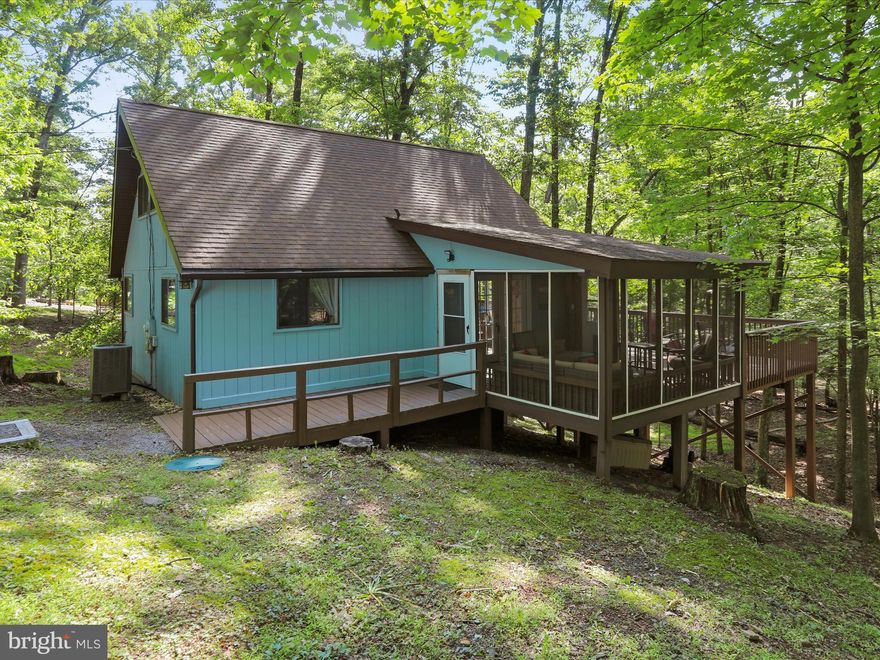 Sweet Simplicity on Nearly 2 Wooded Acres

Tucked into the trees on a serene and sprawling 1.99-acre homesite in The Woods, this well-maintained chalet-style retreat offers easy living, peaceful surroundings, and classic charm. With nearly all furnishings conveying, it’s truly move-in ready—just pack your toothbrush.

Inside, the vaulted great room welcomes you with a wall of windows and a ceiling fan—filling the space with natural light and forest views. The efficient kitchenette makes mealtime a breeze, and the main-level bedroom adds comfort and convenience. Upstairs, a loft offers flexible space for guests, a home office, or a cozy hideaway.

Comfort meets nature in the generously sized screened porch, enhanced by a ceiling fan for breezy serenity. Just beyond, an expansive open-air deck invites outdoor dining, stargazing, or quiet reflection in nature.

Highlights: 1.99-acre wooded homesite with privacy and natural beauty; Vaulted ceilings and a wall of windows in the great room; Screened porch and large open deck—ideal for entertaining; Water heater replaced approx. 2 years ago; Entire home and roof professionally softwashed; New septic tank access lid for easy maintenance; All furnishings convey (except the hammock!); HOA dues: $66.67/month; Optional Class B Membership available; $3,150 initiation fee; $1,600 annual dues

Sweet, neat, and nestled in nature—this chalet is your low-fuss woodland escape with high-quality perks.