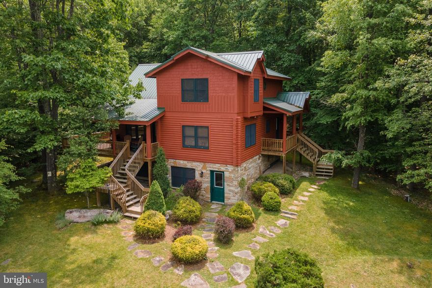 This 4BR/3BA vacation home retreat is the epitome of rustic luxury! Located in the community of Gallatin Woods conveniently located just a few minutes to all Deep Creek Lake restaurants, marinas, shops, and the Wisp ski resort. The wooden interior fills in with an abundance of natural light and the log exterior blends in perfectly with the outdoor wooded setting. This vacation home features stainless steel appliances, large rooms throughout, 2 stone fireplaces, a metal roof, lots of decking, covered porches, 3 fully finished levels, landscaping, and a newer hot tub. Exceptionally maintained. Great rental potential!