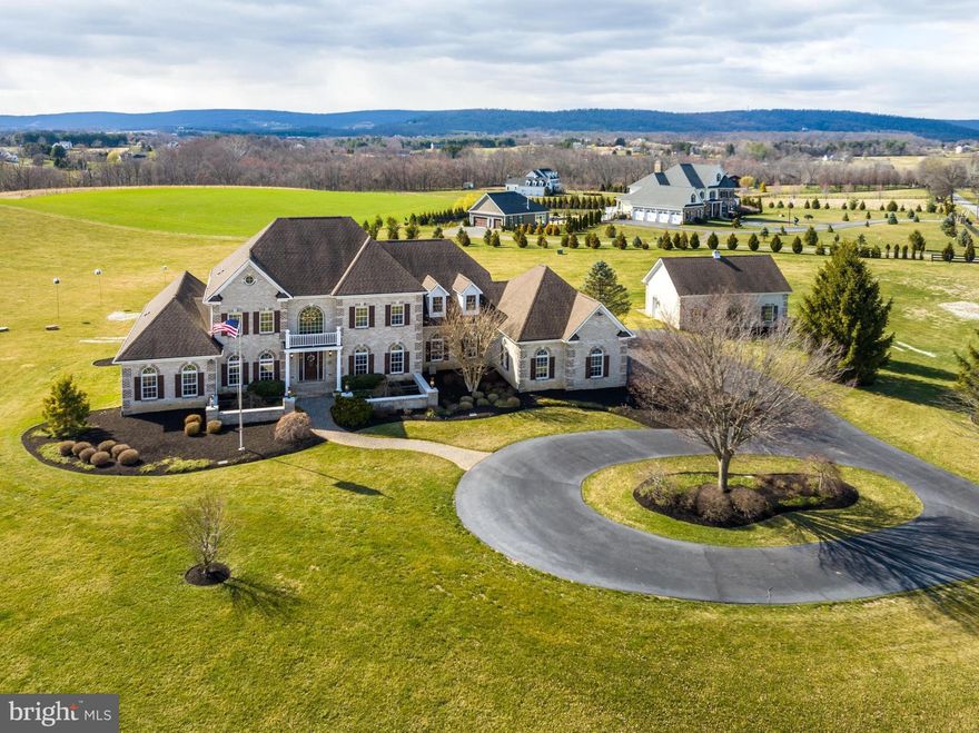 Introducing 37905 Baker Mill Rd, a stunning property with majestic views of the Blue Ridge Mountains . This magnificent estate boasts a sprawling 7,528 sf of living space and is handsomely sited on 11 rolling acres that are totally fenced. As you make your way up the private driveway, you'll be greeted by the breathtaking natural beauty of the surrounding countryside. A circular drive in front of the house leads to an impressive front entrance. Inside, you'll find a grand foyer that leads to a spacious light filled open floor plan with ten foot ceilings. The gourmet kitchen features stainless steel appliances, custom cabinetry and granite countertops, making it the perfect place to cook up a feast for family and friends. The adjoining two story Great Room is an entertainer's dream, complete with a fireplace and plenty of space to host gatherings of any size. The expansive deck is perfect for outdoor dining or just to enjoy watching the sun set. The main level primary suite is a true oasis, featuring a luxurious spa-like bathroom, a sitting area with sweeping views of the surrounding countryside. The home also features four additional bedrooms, each with its own en-suite bathroom. The finished lower level with an impressive custom bar has nine foot ceilngs, gas fireplace, workshop, full bath, au pair suite with full kitchen and ample storage space.  For the car buff, there is a three car attached garage and a two car detached garage. Located just minutes from downtown Purcellville, this home offers the perfect combination of privacy and convenience.