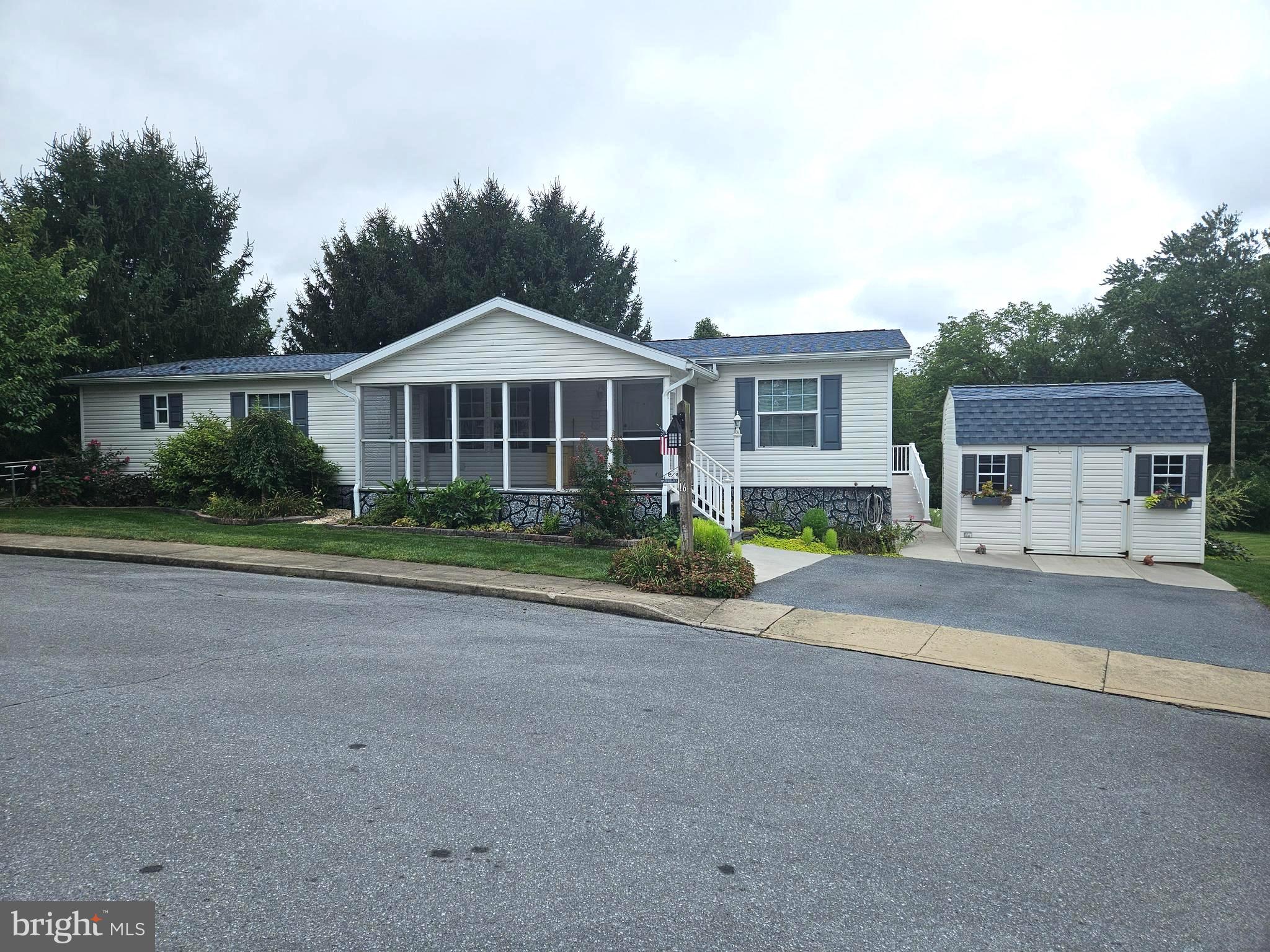One of a kind home in this 55+ community with a custom build sunroom addition and two ramps for accessibility! Well maintained home with large dining area, breakfast area & a gorgeous sunroom with a great wooded view! Spacious owner's suite with walk-in shower, double vanity and direct access to the laundry room. Enjoy the beautiful back view from the low maintenance deck or sit and enjoy the community in the large screened in front porch. Plenty of storage with a shed & the under sunroom storage area. Don't miss your opportunity to own this great home in a beautiful country community! LOW park rent $380 includes water, sewer & trash!! Quick possession available