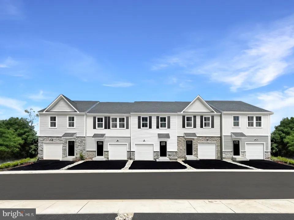 Experience elevated living in this exquisite 3-bedroom, 2.5-bath end-unit townhome in the prestigious Downingtown Ridge community, ideally positioned on a premium homesite that offers unmatched privacy, abundant natural light, and sweeping scenic views. Boasting 2,084 sq. ft. of refined living space, this carriage-style residence features a finished lower-level recreation room ideal for a private theater, fitness studio, or executive home office, while the open-concept main level showcases designer finishes, a gourmet kitchen with quartz countertops and elegant cabinetry, and seamless flow to a private deck perfect for sophisticated entertaining or serene relaxation. Upstairs, retreat to the luxurious owner’s suite with a spa-inspired en-suite bath and spacious walk-in closet, complemented by two additional bedrooms designed for comfort and versatility. With a full premium appliance package included, luxury vinyl plank flooring throughout, and lawn maintenance fully taken care of, you’ll enjoy effortless, maintenance-free living in a community renowned for its peaceful, tree-lined setting and unmatched convenience to top-rated schools, upscale shopping, fine dining, and major commuter routes.