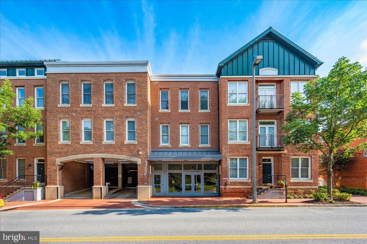 Welcome to the penthouse of the Maxwell Building — a top-floor, 2-bedroom, 2-bathroom condo offering unmatched luxury, prime downtown location, and some of the most spectacular views in Frederick. This rare rental opportunity combines elegant finishes, abundant natural light, and premium building amenities to create a living experience you’ll be hard-pressed to find anywhere else. From the moment you step inside, you’re greeted by a welcoming foyer — a versatile space perfect for a small desk, reading nook, or a stylish bench to kick off your shoes after a stroll along Carroll Creek. The home opens into an airy, open-concept living and dining area, where vaulted ceilings amplify the sense of space and light. A cozy fireplace adds warmth and character, making this the ideal place to unwind or entertain. Two private balconies offer completely different experiences: one overlooks historic Carroll Creek, where you can listen to the soothing sounds of fountains and watch the gentle flow of water; the other faces the charming Maxwell Plaza courtyard, perfect for sipping your morning coffee. The updated kitchen is a chef’s delight, featuring brand-new quartz countertops, a gas range for precision cooking, and abundant cabinetry for all your storage needs. Hardwood floors run through the main living areas, while both bedrooms have been upgraded with brand-new carpeting for ultimate comfort. The spacious bedrooms are filled with natural light, and the two full bathrooms are beautifully appointed with tasteful finishes. This secure, elevator-access building ensures peace of mind and convenience, with controlled entry and well-maintained common areas. Your lease includes two reserved garage parking spaces and access to a private indoor, lockable storage unit — a rare luxury in the heart of the city. Residents also enjoy the on-site fitness center, so staying active is easy without ever leaving home. Perfectly located just steps from Downtown Frederick’s finest dining, boutique shopping, art galleries, and entertainment, this home offers the very best of city living with a touch of tranquility.