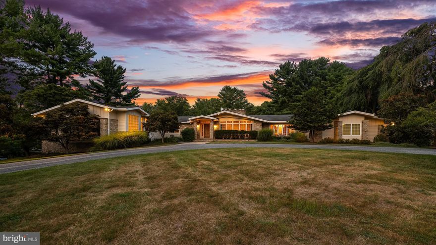 This sprawling reimagined rancher effortlessly combines mid-century architectural design with contemporary lifestyle concepts to create crisp and elegant, sun-filled living spaces that exhibit precision craftsmanship and exacting attention to detail. The expansion has created a flowing, versatile floor plan with marvelously spacious living areas and bedrooms, soaring vaulted and cathedral ceilings, gorgeous hardwood floors and rooms simply filled with natural light. Special attention was given to sophisticated custom built-ins and refined material selections such as upgraded millwork, fabulous lighting and handsome Andersen windows and doors. A remarkably sizable kitchen is a dream for every at-home cook, offering abundant countertop and custom cabinetry space, stainless appliances, and fabulous built-ins.  You'll want to take a few extra minutes each morning to enjoy your morning coffee in the bright and sunny morning room while reclining on the chic banquette while taking in the views of the beautiful back yard.  The primary suite impresses with generous proportions, a 10-foot ceiling and elegant window treatments plus a dressing room and luxury owners' bath with jet tub, walk-in shower and gorgeous custom cabinetry. The capacious lower level allows for a multitude of flexible uses and boasts a kitchenette, rec room, large 5th bedroom suite with full bath, bonus room, half bath and abundant storage.  Enjoy dining al fresco and relaxing on the various outdoor living options: the elevated terrace or the brick paver patios overlooking the rolling back yard and trees beyond.  This magical home exudes warmth, light and a sense of quiet sophistication, both inside and out.  Welcome home to this fabulously inviting retreat!