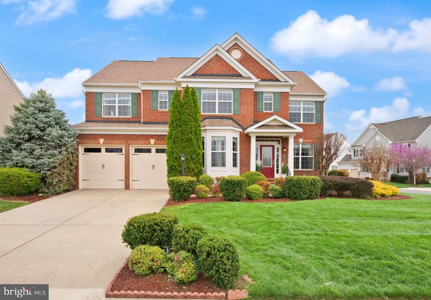 Tucked within one of Brambleton’s most sought-after enclaves, on a prominent corner homesite framed by premium landscaping and producing apple trees, this distinguished former model home quietly reveals itself as a residence of rare intention and presence. Reintroduced with a refined, modern aesthetic — including fresh paint throughout and brand-new LVP flooring across the bedrooms and lower level — the home now presents with a renewed sense of brightness, cohesion, and effortless livability.

Originally conceived to showcase the builder’s highest level of craftsmanship, the residence embodies what can only be described as model-home excellence at scale. With nearly $200,000 in curated upgrades, it offers a level of finish, detail, and architectural expression that elevates it far beyond the ordinary.

A gracious entry introduces interiors defined by proportion, light, and craftsmanship. Extensive crown moldings, tray ceilings, and layered ambient lighting create depth throughout, while the home unfolds across more than 4,800 square feet with a natural, uninterrupted flow between formal and informal spaces.

At its heart, the main level is anchored by an expansive family room and a chef’s kitchen designed for both everyday living and elevated entertaining. Granite countertops, a gas cooktop, under-cabinet lighting, and upgraded appliances are seamlessly integrated alongside a generous center island. The adjoining breakfast area and sunroom are bathed in natural light, opening outward to a Trex deck and patio — an effortless extension of the living space designed for indoor-outdoor gatherings.

A private study, quietly set apart, offers a refined workspace with custom built-ins and double doors, while integrated whole-home features — including built-in speakers, a humidification system, and a full water filtration system — ensure comfort is experienced as much as it is seen.

The upper level is anchored by a serene primary suite, where a tray ceiling and dedicated sitting area create a sense of retreat. Dual walk-in closets and a spa-inspired bath with soaking tub and dual vanities complete the space. From here, a rare and memorable perspective unfolds — seasonal fireworks over Hanson Park, visible from the privacy of your own bedroom, offering a lifestyle moment few homes can replicate.

Three additional sun-drenched bedrooms overlook a serene, glistening pond, where the water sparkles like scattered pearls beneath the golden sunlight—each thoughtfully designed with its own spacious walk-in closet.
The lower level, now enhanced with new LVP flooring, is both expansive and versatile. A large guest suite, walk-up access, and pre-wiring for a home theater create an ideal environment for extended living, entertaining, or recreation — adaptable to a variety of needs.

Beyond the walls of the home, the setting continues to impress. This home with Fully fenced backyard, is just steps away from Hal & Berni Hanson Regional Park, where miles of trails, open green spaces, athletic fields, and water features provide an immersive outdoor lifestyle. A school bus stop directly in front of the home adds everyday safety and convenience, while nearby Brambleton Town Center and Corner Plaza offer a seamless blend of dining, retail, and essential services.

Thoughtfully maintained and comprehensively updated — including a 2024 water heater, 2022 washer and dryer, upgraded kitchen appliances, radon mitigation system, and whole-house security system — the home delivers a true turnkey experience, free from the typical demands of ownership transitions.

Elegant yet approachable, refined yet functional, this residence is more than a former model home — it is a fully realized living experience, where design, comfort, and location converge with quiet confidence.