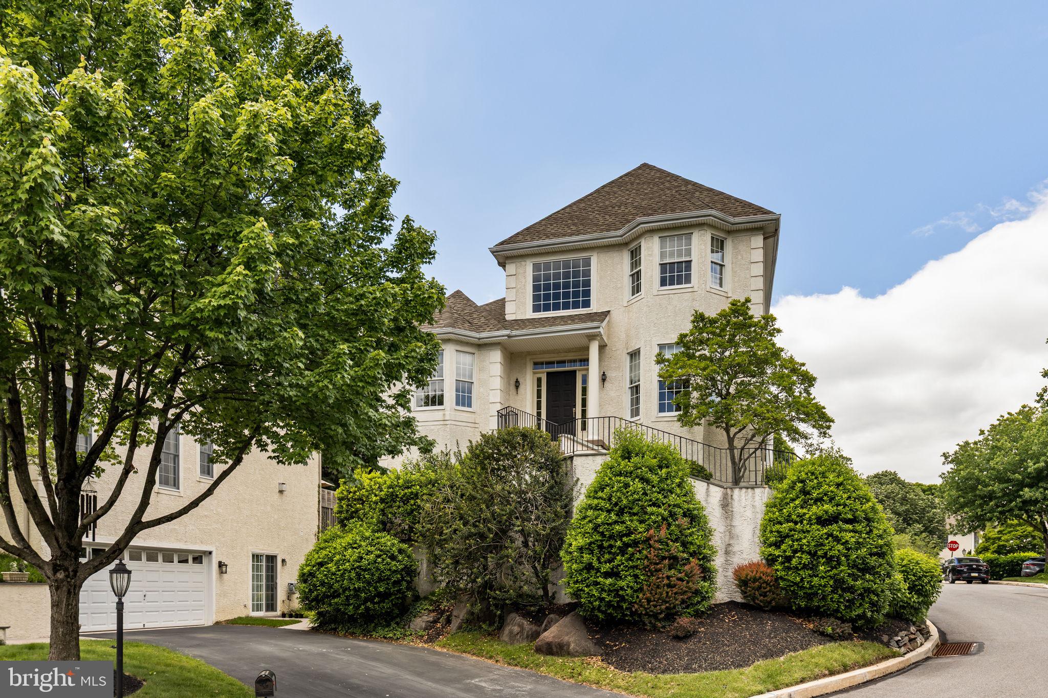 Perched on a hilltop in the sought-after Merion Hill community, 1015 Riverview Lane offers the perfect blend of elegance, privacy, and convenience just minutes from Conshohocken.
A gracious two-story foyer introduces the home’s open floor plan, complete with custom millwork and gleaming hardwood floors. Sunlit formal living and dining rooms feature oversized windows and crown molding, while the spacious living room includes a cozy gas fireplace. The open-concept kitchen is outfitted with stainless steel appliances, a gas range, and access to a large deck with a retractable awning and sweeping views of Conshohocken. The main level also features a generously sized primary suite with two walk-in closets and a luxurious ensuite bath, complete with soaking tub, dual vanities, a separate shower, and abundant storage. A powder room completes this floor.
Upstairs are two well-proportioned bedrooms with ample closet space and a shared full bathroom. The walk-out lower level offers even more flexible living space, including a large family room with access to a beautiful stone patio, a fourth bedroom, a full bathroom, a bonus room ideal for a home office or gym, and a laundry room. Direct access to the two-car garage completes this level.
Merion Hill is ideally located near major highways (I-76, I-476, and the PA Turnpike), SEPTA regional rail, and just a short drive to Conshohocken, King of Prussia, Philadelphia, and the Main Line. Lawn care and snow removal are included in the low-maintenance HOA. This gem won’t last—schedule your private showing today!