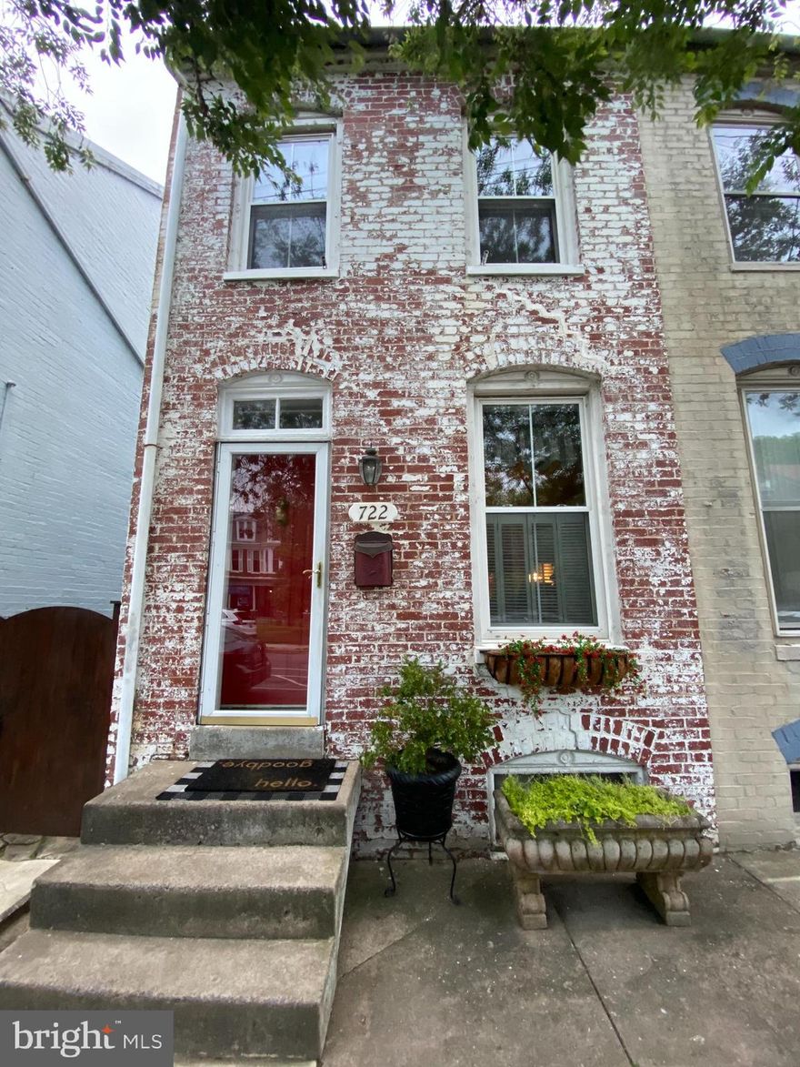 Pro Photos coming! Full of charm and warmth, this early 1900s semi-detached row home offers timeless character just blocks from the heart of downtown Frederick—outside the historic district but close enough to enjoy all the shops, restaurants, and energy.
From the moment you step through the front door, this home feels inviting, with beautiful hardwood floors, warm décor, and custom carpentry details throughout that give it a truly special feel. The main level blends classic charm with thoughtful updates, including a beautifully updated kitchen with space for a full dining table, a separate dining room with electric fireplace for added warmth and ambiance, the convenience of main-level laundry, and a full bath on the main level.
Upstairs, you’ll find comfortable bedroom spaces along with a second full bath on the bedroom level, including a primary bedroom with tray ceiling and a rear bedroom featuring a private balcony overlooking the backyard—a perfect spot to unwind.
The finished lower level adds a cozy rec room along with valuable storage space, while the finished third-floor attic offers even more flexibility as a den, guest room, or lounge area.
Step outside to enjoy a beautifully designed backyard complete with a patio, charming brick walkway, and landscaped, fully fenced yard that leads to a nice sized storage shed and off-street parking—a rare find in this location.
Character, comfort, and convenience come together in this inviting downtown home—perfect for those who appreciate charm and want to be close to it all.
