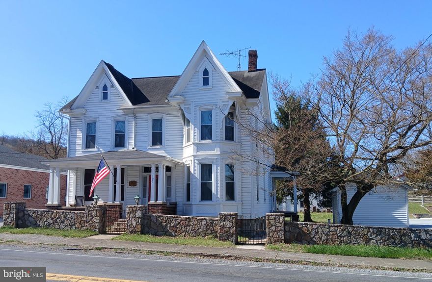 Charming 1893 Victorian in the Historic District of Hedgesville, WV

A piece of local Hedgesville history! This lovingly restored 1893 home has 11 rooms, including 3 bedrooms and 1.5 bathrooms (no tub).  This home combines Victorian charm with modern upgrades. Four covered porches. Maintenance-free vinyl siding, with new half-round gutters in rear of home. 

Kitchen has new cabinets, waiting for a buyer’s choice on countertops, backsplash, flooring, and appliances. 

Bay windows, fireplace, floor to ceiling original windows in front sitting room.  

Hardwood floors
Modern windows for energy efficiency
Radiator heat, serviced recently with an oil-burning furnace
A good well and public water availability
Original to house side outbuilding would make excellent workshop
Large attic space and a 3-bay, two-story garage for storage

The property may have potential for light commercial use (such as offices).