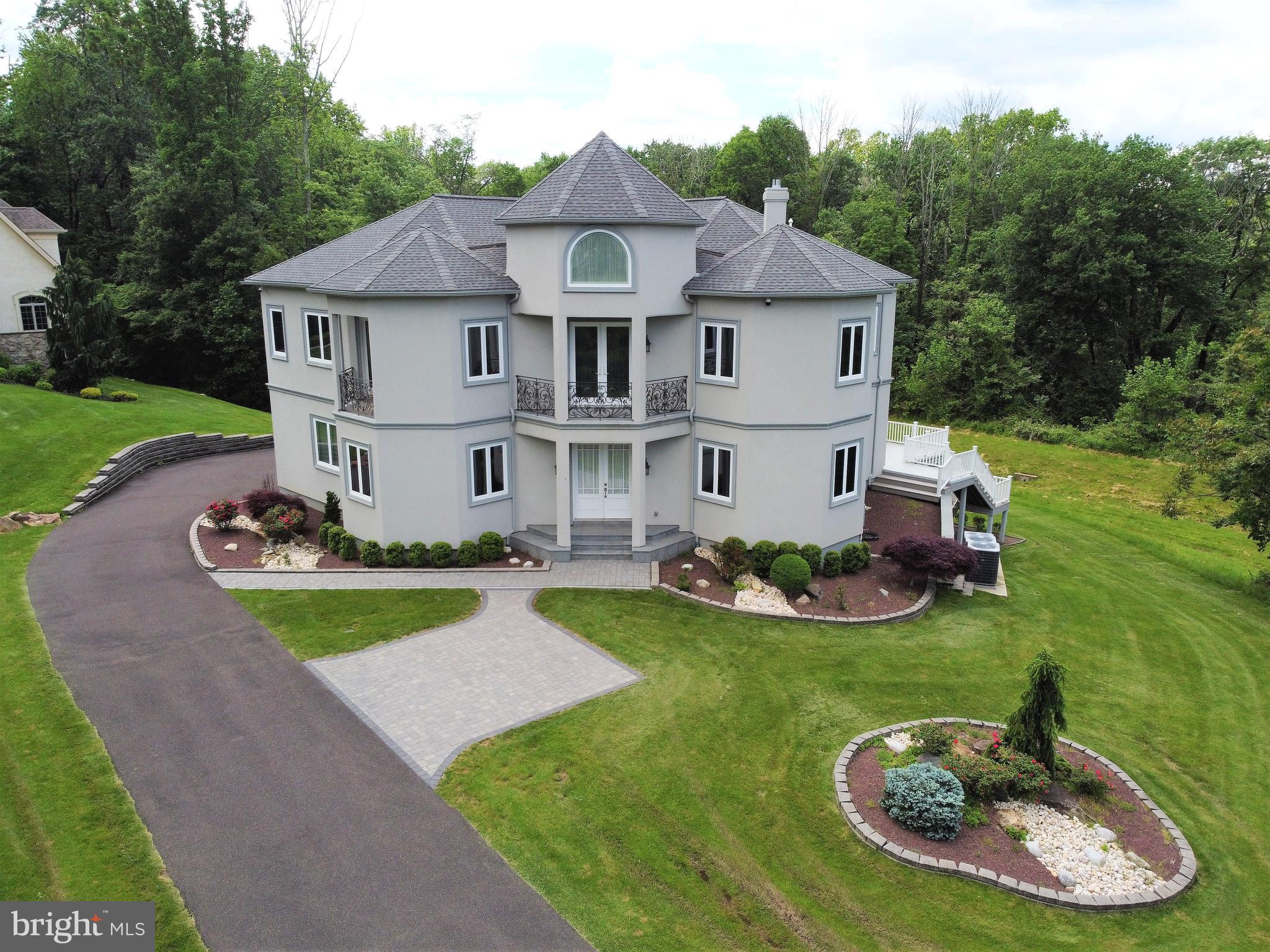 Built in 2015 and situated on 1.6 acres of land, this custom home in the sought after Saddlebrook enclave boasts 6,700 sq ft of living space not including the basement. This home has 5 large bedrooms, 5 full bathrooms, 2 additional half bathrooms, custom-designed open floor plan with 10’ ceiling throughout including the basement all of which sits in a quiet cul-de-sac overlooking Pennypack Preserve in the prestigious and award-winning Lower Moreland School District. A grand entrance door opens to a dramatic 2 - story foyer (21') with turned staircase featuring see through stairs going to 2nd floor, open staircase lined with metal sculpting going into the basement, and 2nd floor overlook but not before you’re greeted by a private coat closet alcove. The first room to the left is large office with custom built-in cabinetry and table. A Living Room, with venetian plaster framed wall designs, provides additional entertaining space before entering the Family Room. This area has a wet bar complete with custom cabinetry, sink, wine fridge and wine rack, a gas stone-finished fireplace and a French door entrance to a spacious fiberglass deck overlooking the preserve. Next is the kitchen which comes with custom 42" cabinetry, granite counters, large center island with butcher block that seats 4 across comfortably, top of the line Dacor appliances that include microwave, 1 built in oven, additional standing range, Bosch dishwasher and range vent, panel sub-zero refrigerator that blends in with the rest of the cabinets and breakfast area with corner television sunlit with large windows on two sides. Adjacent to kitchen and family, is the formal Dining Room with perimeter wall sconce and intricate coffer ceiling, although it’s currently used as a kids study. A tile lined Powder room, large Mud Room with custom cabinets and 2nd refrigerator, additional coat closet and over-sized 3-car epoxy floor garage with ceiling shelving complete the 1st floor. Upstairs you’ll find a circular hallway overlooking the grand foyer and ending with an open Den that has built-in cabinetry and media center ideal for library, study, or play area with adjacent front-facing balcony accessible by beautiful French doors. The first large Bedroom has an alcove walk-in closet, separate door to additional balcony and access to Jack and Jill 2 sink full bathroom and private toilet that connects to larger Bedroom with its own alcove walk-in closet also accessible from the circular hallway. There is an additional large bedroom on this floor with its own full private bathroom and walk-in closet. There is also a generous master suite with a private balcony, two large custom walk-in closets that include a makeup table. A master bath a shower and a free-standing soaking tub, his and her sinks as well as a European style water closet with a bidet. Large Anderson windows complete this area. A large and deep linen closet, a media closet as well as a laundry room with sink complete the 2nd floor but not before a dramatic spiral staircase leads to a hidden 3rd floor reading nook complete with window and coffer beams. The custom finished walkout basement has 10’ ceilings, a full bedroom with an en-suite full bath, and a movie theater room already pre-wired for equipment and with 2 step theater seating. The French doors lead to an EP Henry patio situated underneath the deck. Luxurious finishes include custom Hunter Douglas shades throughout the house along with custom window tinting in every window and door allowing for both privacy as well as environmental benefits. The entire home is outfitted with hidden wiring (including Ethernet), a CCTV system as well as built-in speakers throughout the home and on the deck, all centrally managed from within a media closet in the 2nd floor. Paved lined driveway, garage in rear, hardwood flooring, custom woodwork, custom iron railings, custom landscaping, rounded drywall corne