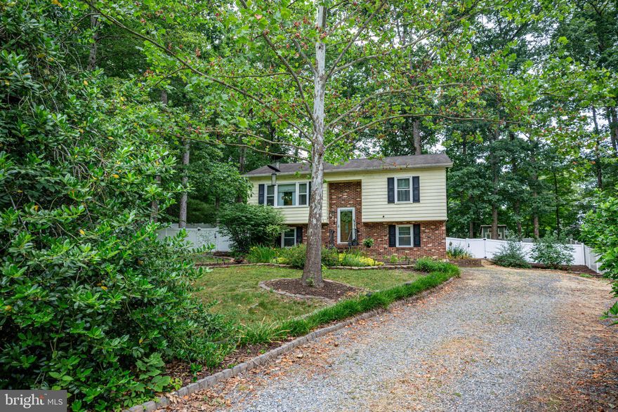 Welcome home! This beautifully presented and maintained home offers 4 bedrooms, 2 bathrooms and sits on just under 0.5 acre lot. Large kitchen offers tile backsplash, under cabinet lighting, plenty of storage  and leads onto the deck overlooking the beautifully landscaped rear yard.  Upper level also boasts beautiful FR/Dining room, 2 bedrooms and a full bath. Lower level has a family room with plumbing installed (potential to add 2nd kitchen if desired), with an electric fireplace, 2 bedrooms, full bathroom, laundry room and side entrance. Both bathrooms have been updated and have built in Bluetooth speakers. All windows come with transferable lifetime warranty, custom blinds throughout, as well as built in blinds in the front screen door and door leading to the deck.
The beautiful landscaping is evident from first arrival, with both front and rear yards freshly mulched throughout. The fully vinyl fenced rear yard offers a patio area leading from the deck, chicken coop (permitted with the county for 3 hens), large shed with lean-to and a large enclosed natural leaf compost area. No HOA, close to schools, shopping and I-95. Truly a must see!