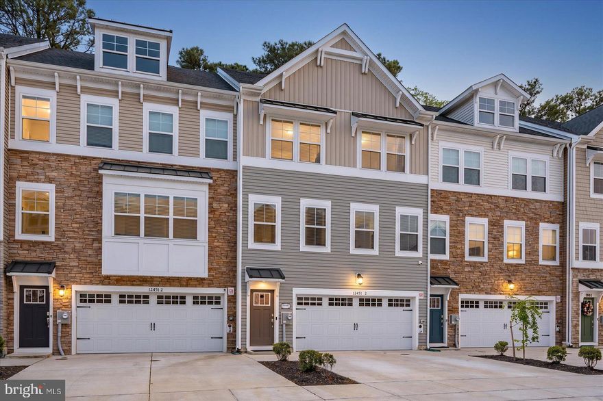 Welcome to Sea Oaks Village — a beautifully designed 2023-built coastal townhome backing directly to a serene wooded buffer for added privacy and tree-lined views. Offering four levels of light-filled living just minutes from the beach, the bay, and everything the Eastern Shore has to offer, this 4-bedroom, 3.5-bath home blends modern construction with a layout built for both quiet mornings and lively gatherings.
Enter through the welcoming front foyer and arrive at a convenient mid-level landing where you can head up to the main living level or down to the ground-floor flex room. That first-floor space features a full bath and a private walkout to the hardscaped rear patio that opens to the tree line — perfect as a home office, media room, gym, guest suite, or fourth-bedroom alternative. The ground level also includes a dedicated laundry/mudroom with direct access from the oversized garage, making everyday in-and-out a breeze.
The main living level is the heart of the home, showcasing an open-concept great room, dining area, and a true chef's kitchen featuring the upgraded package: double wall ovens, stainless appliances, an oversized quartz island with seating for the whole crew, designer cabinetry, and a sun-drenched morning room that opens to an expansive open-air deck — ideal for grilling, sunset dinners, and unwinding around the fire pit while overlooking the woods.
The third level features three generously sized bedrooms, including a serene primary suite with a spa-style en-suite bath (oversized tiled shower, dual vanity, and walk-in closet) plus two additional bedrooms served by a full hall bath. Head up to the fourth-floor loft retreat — a versatile bonus suite with its own private walkout balcony perched at treetop level — easily used as a fourth bedroom, second primary, teen suite, or rec room.
Built in 2023 with all the modern systems, energy-efficient features, and warranty-era peace of mind that come with newer construction, this home lives larger than the square footage suggests, with the wooded rear setting delivering a true sense of escape. Sea Oaks Village offers resort-style amenities including an outdoor pool and clubhouse, sport court, playground, fishing pier, and tranquil ponds and walking paths winding through the neighborhood. A short drive lands you at the white-sand beaches and boardwalk of Ocean City, the wild ponies and protected dunes of Assateague Island National Seashore, and the charming shops, galleries, and award-winning dining of historic downtown Berlin — repeatedly named one of America's Coolest Small Towns. Local favorites like Sunset Grille, Hooper's, On The Bay Bistro, Fager's Island, and the Shark on the Harbor are just minutes away, along with Tanger Outlets, Eagle's Landing Golf Course, and the West OC marinas.