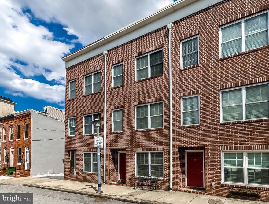 Spacious Locust Point townhome featuring 3 bedrooms, 2.5 bathrooms, 3 car parking (1 car garage plus  2 car pad), and 3 decks!  Built in 2008, this 2000 sqft home has been tastefully updated to provide a sleek modern look.  The kitchen is the heart of the home and has been upgraded with white cabinetry, granite counter tops, tiled backsplash, stainless steel appliances, and an expansive island.  Dine in or out thanks to the large dining room or the adjacent deck off the kitchen.  Also found on the second level is a powder room and the 3rd bedroom/optional living room.  Upstairs you will find two bedroom suites with attached bathrooms along with the centrally located laundry.  Off the rear owner's suite is the second deck, which provides access to the roof top deck that offers spectacular skyline views.  The entry level of the home welcomes you with a large open family room, as well as access to the over-sized 1 car garage.  Storage is not an issue in this home thanks to the massive crawl space.  Schedule a tour quickly, as this home will not last!