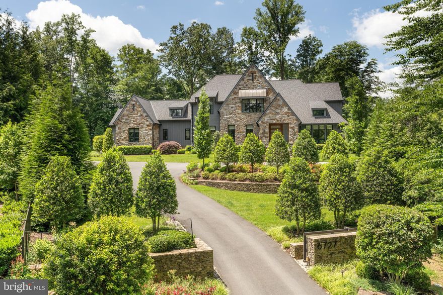This extraordinary home, nestled on a private one-acre lot in Langley Forest, was built in 2020 by Artisan Builders and further customized by the current residents.

The beautifully landscaped setting begins with a gated entrance with stacked stone walls, leading to slightly elevated grounds, a perfect complement to the stunning 6-bedroom, 11,700 sqft home. The stone and cedar contemporary Tudor offers multiple garden areas with boulder formations, extensive evergreen privacy tree fencing, a four-car garage, a motor court for additional parking, a pool and magnificent pool house recently built by Fine Landscape Design. The country-like setting has been designed to both enhance the gorgeous home and the experience that surrounds it.

The modern walnut and glass pivot door welcomes you into the foyer which features European white oak floors. Here you experience views of the chic streamlined fireplace which anchors the living room and sitting room with stunning walnut detailing. Additionally, the foyer opens to a large dining room with elevated ceilings and handsome wood beams and a butler’s pantry.

The spacious kitchen opens to the family room with a vaulted ceiling, spectacular full height windows and a stone fireplace. Bi-folding atrium doors open to the beautiful light-filled screened porch with views of the pool compound and garden beds. The Lobkovitch-designed kitchen has two spacious islands, state of the art appliances and a breakfast room. While perfect for a serious cook, it is also wonderful for informal entertaining and everyday family gatherings. The extraordinary proportions of the adjacent family room and views of the screened porch beyond welcome you to a very special space within the heart of the home.

The elegant main floor primary bedroom has views of the pool house and features a vaulted ceiling with a striking contemporary chandelier, two dressing rooms and a gorgeous primary bathroom with radiant heated floors.

A home office area, two half-baths, a laundry room, mud room, and an oversized 4-car garage complete this level. 

The front staircase with an elegant tulip shaped chandelier brings you to the upper level of the home which offers three large bedroom suites, an additional family room and a expansive walk-in linen closet.

The upper level guest suite, located off the side foyer of the home, offers a spacious bedroom with sitting area, ensuite full bath and views of the side gardens.

The lower level features a full entertainment area with a nicely designed white oak bar with illuminating panels. This area adjoins a spacious family room with a fireplace and barn doors that lead to a golf simulator room or theater room. The oversized mirrored gym has professional gym flooring and opaque double glass entry doors. Additionally, another guest suite, a full bath and a powder room are located on this level.

The recently constructed pool house includes everything one would need to entertain or just relax. The copper ion pool has a serene waterfall feature and is surrounded by an expansive travertine stone patio with multiple seating and lounge areas. The thoughtfully designed pool house includes a covered seating area which is centered around a gas fireplace and TV. The outdoor kitchen has bar seating, a beverage refrigerator, ice maker and Viking grill. The dining area has beautiful sconces on the wood paneled walls and a gorgeous light fixture. The pool suite offers built-ins, a large full bathroom with walk-in shower and dressing area. The finishing details of this pool house integrate seamlessly with the style of the home.

A full security system, landscaping lighting, Lutron and Sonos system, whole house generator, and irrigation system are also included in this very special offering.