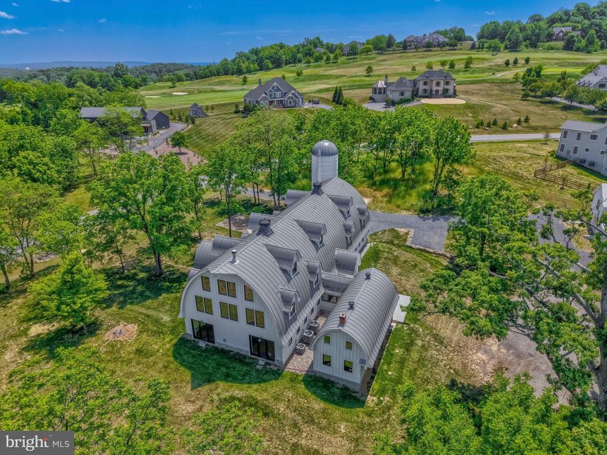 Extraordinary is an understatement for this exquisite estate — a masterful conversion of a dairy barn w/stone silo and a carriage house, blending timeless character with sophisticated modern farmhouse design. Set on three picturesque acres in the prestigious Stoneleigh community, this one-of-a-kind property offers over 9,800 square feet all above grade. Every detail has been thoughtfully curated to honor the home’s original architecture while embracing luxurious modern living.
 
Upon entering, you are greeted by soaring ceilings, dramatic open spaces, dual staircase, intimate reading nooks, and stunning remnants of the original barn seamlessly woven throughout the home. The ceilings proudly showcase the barn’s original wood structure, creating warmth, texture, and extraordinary architectural character throughout the living spaces. Walls of windows flood the interiors with natural light, highlighting the striking stone fireplace, exposed architectural elements, and exceptional craftsmanship found at every turn. Custom wood staircases and railings further enhance the home’s remarkable craftsmanship and architectural beauty.
 
Designed for both grand entertaining and comfortable everyday living, the home features five spacious bedrooms and 4.5 beautifully appointed baths, including a desirable main-level bedroom suite. The showstopping chef’s kitchen is outfitted with high-end appliances, (2 dishwashers!), gorgeous soapstone countertops, a beverage refrigerator, and exceptional gathering spaces that flow effortlessly throughout the home. A private home office is tucked away in a separate wing, offering ideal privacy for work, guests, or creative pursuits.
 
Adding even more versatility, the property also includes a beautifully finished one-bedroom carriage house, complete with its own stunning kitchen and bath — perfect for guests, extended family, or au pair living.

The expansive three-acre setting offers a separate garage/workshop and large run-in shed.  There are endless possibilities, including ample room for a future pool and outdoor entertaining oasis. While located in Stoneleigh, this property is not part of the HOA, offering rare flexibility. Owners may also choose to join the prestigious Stoneleigh Golf & Country Club for access to golf, dining, and social amenities. 
A home unlike anything else on the market — rich in history, breathtaking in scale, and unforgettable in design.