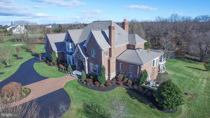 Custom Italian Tile & Marble. Granite in the kitchen & all baths. Two story foyer & family room. Custom stone & brick work inside & out. Expansive gourmet eat-in kit w/ living space. Huge deck across the back w/ spacious 3 season room overlooking spacious yard & private pond. Theater room in bsmt. Ready to finish bar, wine cellar & safe in basement. 4 car side load garage. Fios! View Virtual Tour!