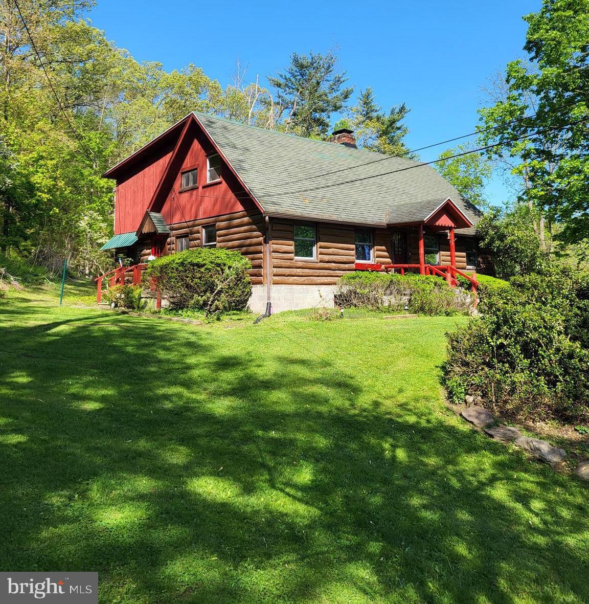Experience the warmth and character of this beautiful log cabin nestled on a scenic lot in Laceyville. Inside, you'll find authentic log walls, exposed ceiling beams, and hardwood floors that give the home timeless rustic charm. The living room is a true highlight, featuring a brick wood-burning fireplace and large windows that fill the space with natural light and frame views of the surrounding landscape. The spacious kitchen offers plenty of room for cooking and gathering, while the large dining room includes a larger window perfect for enjoying the beauty of nature right from your table. Upstairs, you'll find three comfortable bedrooms and a versatile bonus room ideal for a home office, playroom, or creative space. An attached garage and carport provide convenient parking, and the property includes two sheds for extra storage. There's also a detached screened-in sunroom—perfect for relaxing in the warmer months. The lot is serene and open, offering peaceful mountain views and natural gas access. Mineral rights are included with the property, but the seller is open to selling for $15,000 less if the buyer chooses to exclude them.
