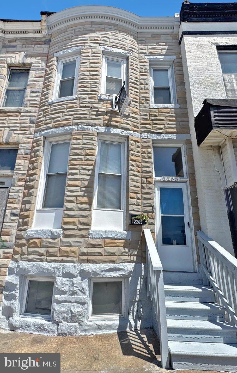 Welcome to 2265 Reisterstown Road, a beautifully updated 5-bedroom, 2-bathroom brick townhome ideally situated in Baltimore’s dynamic Parkview community. Remodeled in 2017 and freshly refreshed in 2025, this spacious residence blends timeless character with modern comfort. The main level features gleaming hardwood floors, a generously sized bedroom and full bathroom, and a large eat-in kitchen outfitted with granite countertops, ample cabinetry, and sleek black and stainless steel appliances—perfect for everyday living and entertaining. Upstairs, you'll find four additional bedrooms with plush wall-to-wall carpeting and a fully remodeled bathroom designed for contemporary comfort. The finished basement expands the living space with a bonus living room area, an additional flex room ideal for an office or guest suite, and a walk-out to the rear of the home. Central heating and cooling ensure year-round comfort, while the new roof (2017) and smart updates throughout provide peace of mind. A private rear parking pad for one vehicle adds convenience. Enjoy easy access to the newly redeveloped Parkview Recreation Center, Mondawmin Mall, metro transit, the Baltimore Zoo, Druid Hill Park Lake redevelopment, neighborhood parks, and the Shops at Mondawmin. Don’t miss your chance to own this turn-key home in a rapidly transforming area.