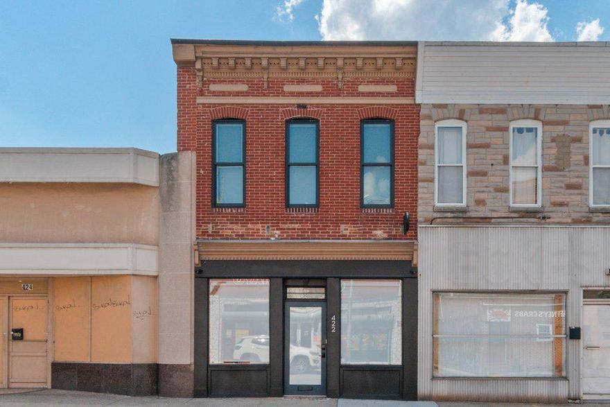 Pristine live/work gallery and residence in Baltimore’s Highlandtown Arts District, formerly known as Springsteen Gallery. This turnkey mixed-use property offers over 2,600 square feet of thoughtfully designed commercial and residential space and will appeal to the most discerning of buyers. The property benefitted from two extensive renovation phases — first transforming the gallery and commercial areas, followed by a comprehensive redesign of the residence above — resulting in a seamless blend of contemporary living, professional functionality, and architectural detail. The striking façade has been carefully restored with renovated brickwork, updated doors and windows, and a restored second-floor center window that complements the replacement of the three front-facing upper windows. Additional exterior improvements include a new roof and gutters, installed in 2021, along with outdoor security cameras, a secure exterior hydrant, and a clean rear alley for convenient access. The commercial/gallery level was designed with flexibility, safety, and professionalism in mind. In 2021, the commercial and residential portions of the property were separated with two-hour fire-rated walls, ceilings, and doors. The gallery space features skylights, gallery lighting, recessed lighting, safety exit signage, and exceptional natural light throughout. Additional first-floor amenities include a private office, security room, utility closet with stainless steel utility sink, half bath, and a handicap-compliant bathroom. The building is also equipped with three separate BGE meters serving the commercial, residential, and egress/common areas independently. The fully renovated upper-level residence showcases sophisticated modern finishes and carefully curated design elements throughout. The designer kitchen features engineered white oak flooring by ADM Flooring, custom Ikea cabinetry and countertops, a Grohe faucet, Kraus sink, Bosch appliances, and a gas-powered range with hood. An oversized island provides seating and entertaining space, while room for a dining table adds functionality and warmth. The elevated living area is filled with natural light from skylights, transom windows, and oversized windows with custom flower boxes. Architectural details include custom stairs with an oak slat wall and railing system, frameless custom interior doors with steel frames, premium chrome hardware, and European hinges. The spa-inspired bathroom was meticulously renovated with terrazzo tile flooring, Zia ceramic wall tile, a flush-installed Wetstyle shower pan, Kurdi Schluter waterproofing system, Laufen x Kartell vanity, and premium designer fixtures, including Grohe and Duravit elements. The spacious bedroom includes a walk-in closet, ceiling fan, and blinds, while recessed lighting extends throughout the residence. A premium ceiling fan with motion and humidity detection adds additional comfort and efficiency. Mechanical upgrades completed in 2025–2026 include a high-efficiency heat pump providing heating and cooling throughout the building and a gas-powered Bosch tankless water heater. The partial basement offers additional utility and storage with rubber mat flooring and storage racks, while the crawl space includes installed vapor barriers for added protection and efficiency. A rare opportunity to own a truly turnkey mixed-use property combining refined residential living with professionally designed gallery and workspace in one of Baltimore’s most vibrant arts communities.