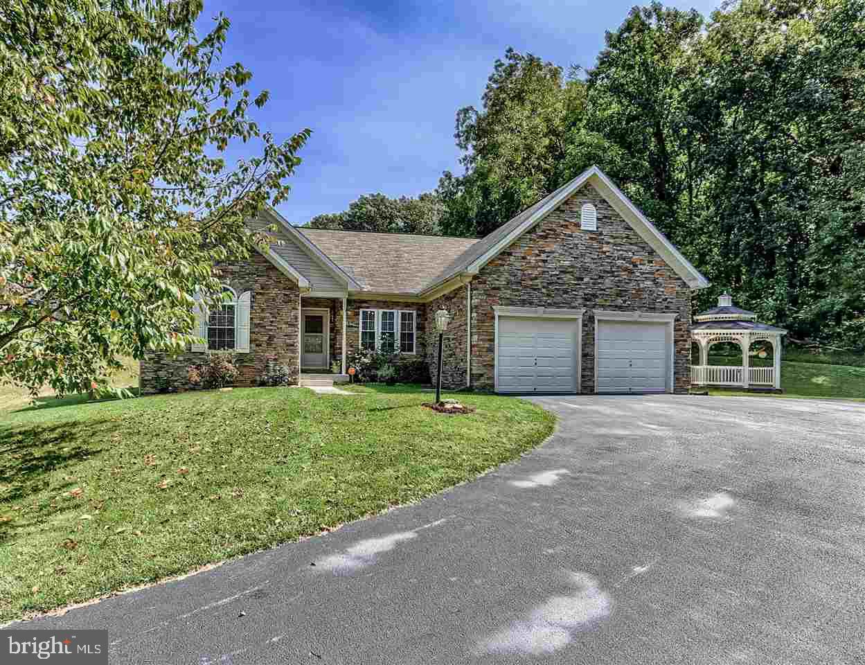 Beautiful Rancher nestled amongst the trees w/private drive on nice 1 acre lot. Bright & Open Kit w/Corian Counters, Dining Area, Pantry & Sliding door to backyard, LR w/Wd Pellet Stove & Sep DR. Mst BR w/WIC, Custom Built-In Wardrobe & Luxury BA. LL FR w/Wet Bar, BA & Walk-Up to partially fenced backyard. Upgrades incl. Vaulted Ceilings, Exterior Stone Front & Hdwd flrs. 2 Car Gar, Gazebo & Cvrd front porch. Peaceful setting & Great location!