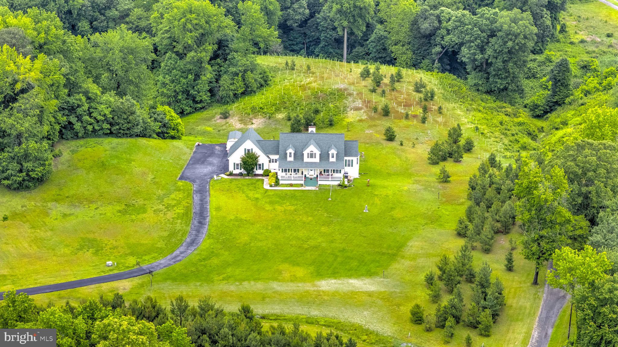 Charming Cape Cod offering over 5,000 sq. ft. of living space, including a fully finished lower level, all nestled on a private 2-acre lot. Enjoy peaceful country living from the inviting front porch overlooking a beautiful front yard. Inside, you'll find a stunning two-story family room with a stacked stone fireplace, a spacious kitchen with granite countertops, and a full-length sunroom that spans the entire rear of the home—providing breathtaking views of the surrounding countryside and local wildlife. The main level features a generously sized primary suite with a full bath, a guest bedroom and bath, plus a convenient powder room. Upstairs includes two additional guest bedrooms, a full bath, and a large bonus room over the garage with a private entrance—perfect for an in-law suite, home office, or potential efficiency apartment. The finished lower level offers a large recreation room, bar area, and another full bath—ideal for entertaining. Additional highlights include an attached two-car garage and a detached garage/shed for extra storage or workspace. Located just minutes from award-winning Herrington Harbour and only 45 minutes to Washington, D.C., this home offers the perfect blend of space, privacy, and convenience.