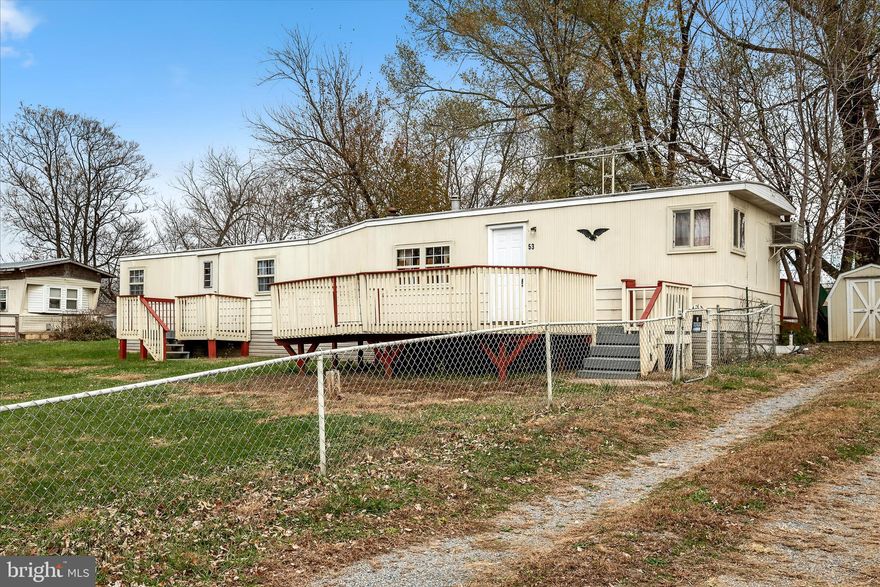 GREAT INVESTMENT OPPORTUNITY! This well-maintained 2 bedroom, 1.5 bath mobile home in Kearneysville features an inviting open concept layout, where the living room, dining room, and spacious kitchen flow seamlessly together. The kitchen features abundant cabinetry, great natural light, and the living room offers the option to add your own heating stove for extra comfort and charm. Step outside and enjoy 3 separate decks, giving you the perfect spot to enjoy your morning coffee or evening sun in a fully fenced in yard. The property also includes a one car garage that features a newly insulated, large workshop, ideal for storage, hobbies or projects. In addition, you'll find two sheds and a carport, providing even more versatility and room for tools and equipment. With its practical layout, generous storage, and prime commuter location, this property is a standout opportunity for buyers seeking value and convenience without the restrictions of an HOA.