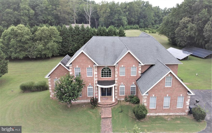 ELEGANCE & CLASS are at their finest in this custom Brick and Stone Colonial Estate home over 7000 square feet finished living space.  Your own little private oasis on almost 6 acres in Upper Marlboro, is just minutes from the Jug Bay Wetland Sanctuary on the Patuxent River. This property is right next to Mt. Calvert Park, a forest conservation area that will give you extra privacy.  From the moment you enter the dramatic 2-story foyer you will appreciate the luxurious details and amenities throughout this beautiful home. There are gleaming hardwood floors throughout the entire main level. Crown moldings, chair rails and wainscoting along with the high ceilings and graceful columns set the tone for this richly appointed home. You can entertain in style with the formal living room and dining room and enjoy plenty of space in the 2 story family room with the elegant 2 story stone fireplace and  the large picture windows that allow plenty of natural light into this home. You can channel your  inner chef  in this truly gourmet kitchen. This kitchen features a Viking 48 inch 6 burner gas stove with double oven and griddle and a high CFU exhaust fan over it, generous amount of granite countertops and loads of cabinets for storage and of course a walk-in pantry and a large island with a Prep sink. You will love the convenience of the rear staircase to the kitchen area from the upper level. There is a large office with French doors and a sunroom with cathedral ceilings on the main level, both with plenty of natural light and plenty of recessed lighting as well. Upstairs you will find three generous sized bedrooms with a Jack and Jill bath between 2 of them and a separate bath in the other bedroom. The huge master bedroom features tray ceilings, recessed lights and a wonderful spa-like en-suite master bathroom with 2 separate vanities, jetted tub, large glassed enclosed separate shower, heat lamp and separate water closet. You will find 2 huge walk-in closets as well! The convenient laundry room is located on the upper level. The expansive basement affords plenty of natural light in the huge recreation room with a wonderful large granite bar with seating for 8 and plenty of room for large gatherings. There is also both unfinished and finished storage areas in the basement and a terrific media room as well. There is another large room with double door entry that is currently used for storage, that would be a wonderful bedroom or office or den. You will find another full bathroom on this level. You can save money on your energy bills with the warm gas heat and there is a solar-panel field as well (buyer to assume lease)   perfect area to maximize sunlight without having them on your roof. Large deck on rear of home is a wonderful outdoor entertainment area.   Plenty of parking is available on the large private circular driveway and the 3-car garage.  Close enough to the city but yet still beautiful rural country setting. Easy commute to Andrews AFB, Washington DC and Points South. Come take a look!