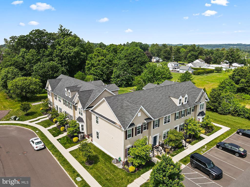 ***OPEN HOUSE CANCELLED!*** Welcome Home! This beautifully maintained end-unit townhouse, built in 2018, is located in the highly sought-after community of The Overlook at Carriage Hill. With 3 bedrooms and 2.5 bathrooms, this light-filled home stands out thanks to its abundance of windows—one of the many benefits of being an end unit. Step inside to a welcoming entryway featuring a coat closet and a convenient half bath. The open-concept main level showcases rich dark wood floors, crown molding, custom lighting, and white kitchen cabinetry that creates an elegant, balanced look. Soaring 9-foot ceilings and sunlit rooms offer a warm and inviting atmosphere throughout. The living and dining areas flow seamlessly into the kitchen, which is outfitted with granite countertops, a center island with upgraded lighting and seating, a stone tile backsplash, and sliding doors that lead to a private patio—ideal for grilling, dining, and entertaining. Unique, thoughtful touches include a custom chandelier incorporating a hay baler and a restored fireplace mantel—both sourced from a historic Bucks County farm—adding charm and character. Upstairs, the primary suite offers a walk-in closet and an updated en suite bath with subway tile, a double-sink quartz vanity, and stylish lighting. Two additional bedrooms and another full bath complete the second level. The finished basement adds valuable living and storage space, featuring recessed lighting, a window for natural light, a laundry room, and a cozy play nook—perfect for kids or flexible use. Enjoy a prime location just 10 minutes from the shops, restaurants, and museums of Doylestown Borough, and within walking distance to Joseph E. Hanusey Park, offering basketball courts, soccer fields, a playground, and scenic walking trails. This home combines comfort, character, and convenience in one of Bucks County’s most desirable communities—don’t miss the opportunity to make it yours!