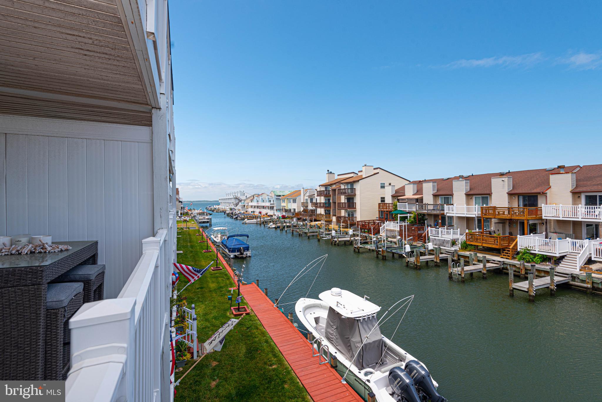Beautiful waterfront beach home with great views and boat slips available for rent. This 2-bedroom, 2 full bath condo has amazing upgrades and renovations inside and out. The primary bedroom and living room have direct access to the large private balcony overlooking the canal and bay. Full kitchen remodel in 2022 include new cabinets, stone countertops, fixtures and stainless steel appliances. Recently updated floors throughout and tiled shower in primary bathroom. Enjoy the common waterfront area with boardwalk and outdoor shower. Building updates include roof and vinyl railings completed a couple years ago. Highly desirable north OC neighborhood close to the beach and great restaurants. Rent your own boat slip for only $150/summer!