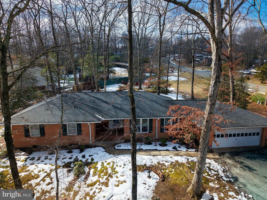 Rare opportunity to own a custom-built, all brick, two-level ranch-style home situated on a corner lot just over one acre—an increasingly hard-to-find lot size in this established area. Appraisal on file—priced in line with the most recent appraised value. Constructed by a member of the original family and thoughtfully maintained across four generations, this property reflects enduring craftsmanship and long-term pride of ownership. The brick-front exterior with vinyl siding is complemented by a newly paved circular driveway, mature trees, rear patio, storage shed, and a two-car garage. Inside, the home offers 3 bedrooms and 2.5 baths. The custom kitchen features beautifully preserved cherry cabinetry (over 40 years old and exceptionally maintained), quartz countertops, pull-out drawers, a Bosch dishwasher, and newer windows in the kitchen and dining areas. Motorized blinds are installed in both spaces. The living and family rooms showcase stunning maple wood paneling, adding warmth and architectural character. Two fireplaces provide flexibility—one gas and one wood-burning (wood-burning fireplace has never been used). The main level includes laminate flooring, with classic black-and-white checkerboard tile in the hallway. Double doors from the living room open to the rear patio, creating an easy indoor-outdoor connection. Major mechanical updates were completed in approx. 2019, including the air handler, heat pump, and central air conditioning system. The unfinished basement offers storage and future expansion potential and includes a sump pump. Conveniently located near shopping, dining, and everyday amenities while offering the space, privacy, and setting of an acre lot.