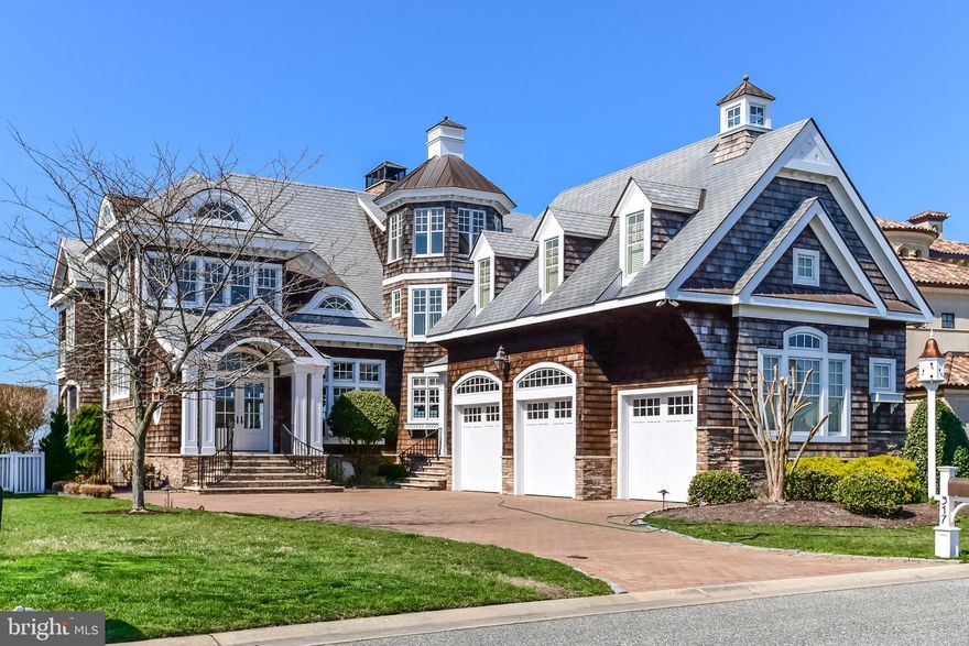 National Association of Home Builders Gold Award Winner. This extraordinary coastal-inspired direct bayfront home, designed for entertaining, is in the exclusive enclave of Heron Harbour in Ocean City, Maryland. Immerse yourself in the ambiance of this luxurious waterfront lifestyle. This sensational 6,454 square feet home offers southwest exposure, optimizing sunset views from its expansive deck and multiple balconies. The property features exceptional craftsmanship with astute attention to detail throughout. A flowing floor plan perfect for entertaining, formal and casual areas showcased in a wall of open glass doors to the bay, five fireplaces, and a wood-burning brick oven make this home an entertainer's dream. The professional chef's kitchen has granite counter tops,  appliances, custom handmade cabinetry, a BBQ lanai, and a walk-in pantry. You will enjoy dining with family and friends in the dramatic dining area complete with jaw-dropping sloped ceilings and a Murano glass chandelier. The tranquil master suite entails a bedroom with a fireplace and stunning cupola, full bath, large walk-in closet, and a bathing retreat, complete with a soaking tub and additional fireplace. There is a total of 7 bedrooms, 5 full baths, 2 half baths, a study, a large home office, and a multitude of living areas. The third floor features a two-bedroom guest suite with a hot tub overlooking the bay and gorgeous sunsets. Other features include an architectural slate roof designed for high winds, full-home A/V system, 9 zone low-cost geothermal heating and cooling, four masonry wood-burning fireplaces, an additional gas fireplace, quality foam insulation, traditional woven cedar shake siding, quarter-sawn hardwood floors, travertine and carrara marble, custom window treatments, upgraded crown molding, central vacuum, 4 tankless water heaters, and an irrigation system. In addition, there is a custom full-home Lutron lighting system, many storage areas, an alarm system and a three-car attached garage. Enjoy the outdoor living area, after a day of boating, with its expansive Ipe (Brazilian Mahogany) deck and an electronic screened lanai for watching endless sunsets. The pier includes a 10-ton boat lift with rare deep-water access to The Big Assawoman Bay, and 96 feet of bulkhead. The home is a true gem to see from both the bay and the neighborhood, perfected with landscaping, lighting, privacy fencing, and brick pavers. With just a 10-block walk or bike to the Atlantic Ocean, your family and friends will be certain to make coastal memories here, whether casual or formal; this home offers it all. Heron Harbour Isle is amenity-rich with two outdoor pools, a kids' pool, fitness center, social room, sauna, locker room, two Har-Tru tennis courts, sidewalks and piers. Be a part of North Ocean City's premier neighborhood and call this award-winning, published, and televised home yours.  Home is being sold unfurnished.