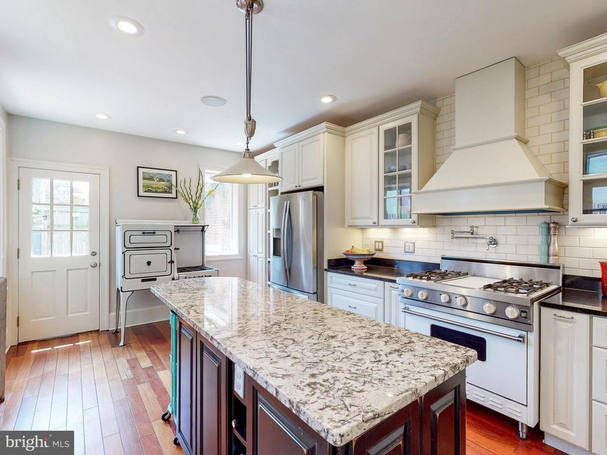 Lovingly renovated true 4 bedroom Butchers Hill home includes a gorgeous farmhouse kitchen with custom two-tone cabinetry, Brazilian cherry flooring, historic style wood baseboards and moldings, paired with 5 large wood windows and 2 exterior doors for an open and inviting space for entertaining that is full of natural light. The kitchen has under cabinet lighting and pendant lights from Restoration Hardware, a breakfast bar area with seating for 4, and a commercial-style 36 in Viking range with pot filler and large furniture-style vent hood.  The coordinated two-tone cabinet and granite countertop combination is carried over into a large island with ample working space for baking. The designers incorporated an antique 1920s Chambers Gas Range that is a beautiful centerpiece tying together historic elements throughout the house. The kitchen connects seamlessly with the fantastic outdoor oasis that includes a patio with pergola and a garden area with historic Richmond style patio pavers that transitions into a natural grass space and flagstone flower beds with established climbing roses, long stem roses, a crape myrtle tree, two forsythia bushes, a rose of Sharon hibiscus tree and morning glories.. The historic stucco walls were restored in 2020 and offer a stunning contrast with the freshly painted wood windows and doors in the rear of the home. The parlor room features tall ceilings, the original plaster cornice (crown) molding, and 3 large windows including the original arch top windows in front that are nearly 99 in. tall and which retain the original working built-in shutters. There is a historic marble mantle with a salvaged cast iron inset arch and this comes with a huge antique mantle mirror. The parlor and front hall in this 18 feet wide house features the original heart of pine flooring that was refinished in 2011. From the 1st floor, the original curved staircase leads to the 2nd floor living space. The front of the 2nd floor includes 2 large bedrooms with ample closet space for easy organization.  The rear of the 2nd floor has a full bathroom with access immediately off of the staircase in the rear hall, a laundry area, and a stand-alone office space with a door salvaged from a historic office building.  The custom built-in desk space offers working and storage spaces for two with options for enclosed and open cabinet space and includes a closet with sliding door for additional storage, direct wired high speed internet and cable access, and is pre-wired for a stereo and amplifier. The rear-most bedroom space has three large windows and two large built-in closet wardrobes.The 3rd floor features the master bedroom suite with original heart of pine flooring.  The master suite spans the full width of the 18 feet wide house with 3 large historically accurate archtop windows in front. It has 2 separate closet spaces, plus a dressing area with vanity, and a master bathroom that includes both a stand-up shower and separate clawfoot tub.In 2018, the roof was replaced and in 2020, the woodwork on the facade was carefully restored. The cornice was freshly painted in 2019 and the stunning front door arch was restored and painted in 2020. The upstairs windows were restored in 2020 including new custom cedar (rot- resistant) wood sills, new glazing and paint on the historic arch top windows.  The facade is a wonderful example of the historic architectural elements found in the Grand Italianate rowhomes in Butchers Hill.  Then home has dual zone HVAC, built-in speaker/sound system, and more! Located 2 blocks from the Hopkins Hospital campus, across the street from Castle Street Park and 2 blocks from Patterson Park, this home is ideally located. Walk to neighborhood favorites like Ministry of Brewing, Water for Chocolate, La Barrita, Charmed Kitchen and BMORE Licks! Note:Parking is easily created in rear of home plus leased spot available right behind the home Check out Video 3D tour: https://my.matterport.com/show/?m=enxk3s6yMU