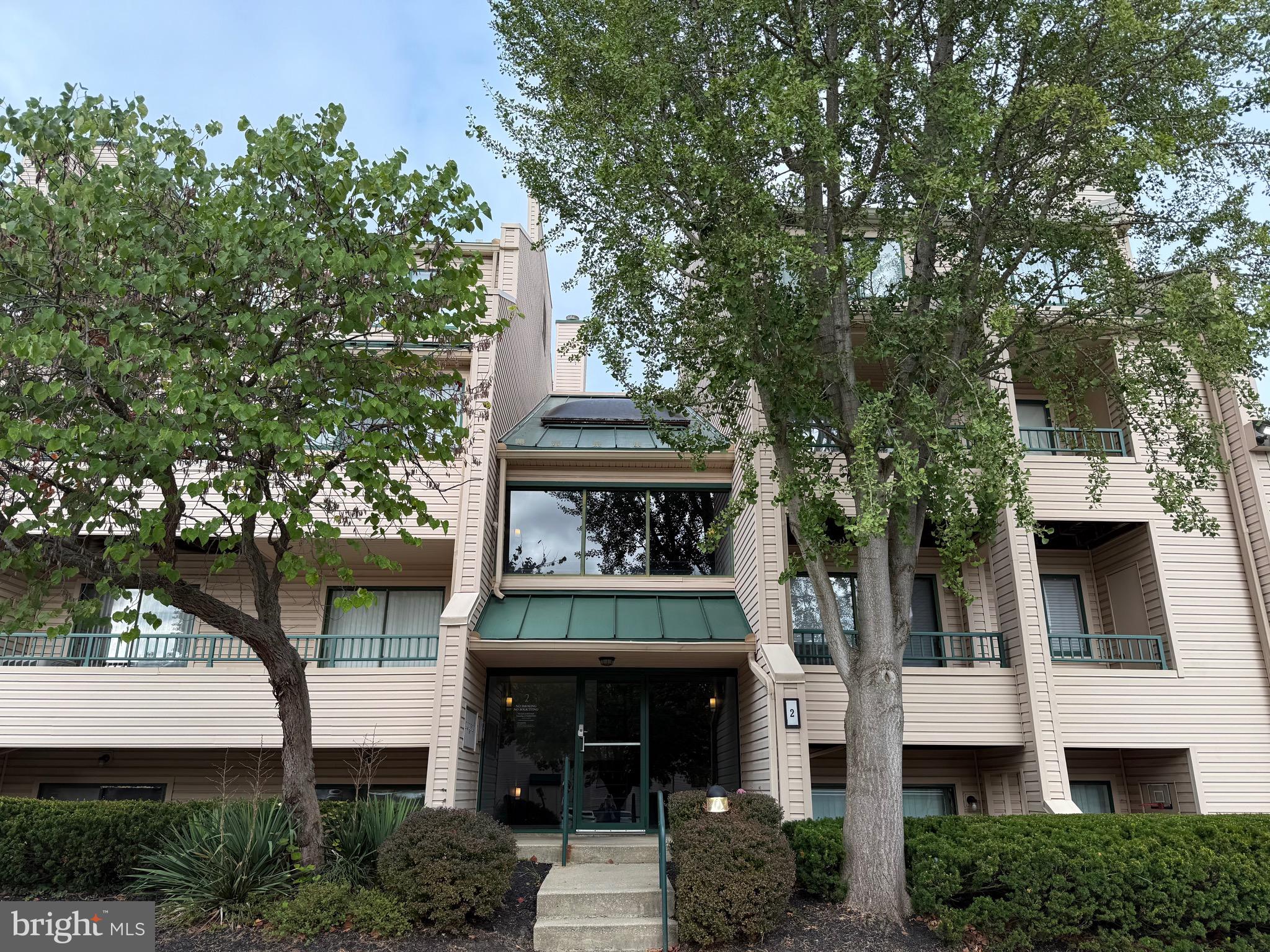 Welcome home to this spacious patio-level condo in The Club at McDonogh! Offering over 1,300 sq. ft. of living space, this 2-bedroom, 2-bath home features a large living room with fireplace and sliding glass doors that open to a private front patio, filling the space with natural light. The kitchen offers into dining space and a wood burning fireplace that leads to a second balcony overlooking mature trees — a perfect spot for nature lovers to relax. Additional highlights include built-ins, ample storage, and both front and rear outdoor living areas. Located in a secure building close to schools, restaurants, shopping, and major commuter routes, this condo is move-in ready and waiting for your personal touch!