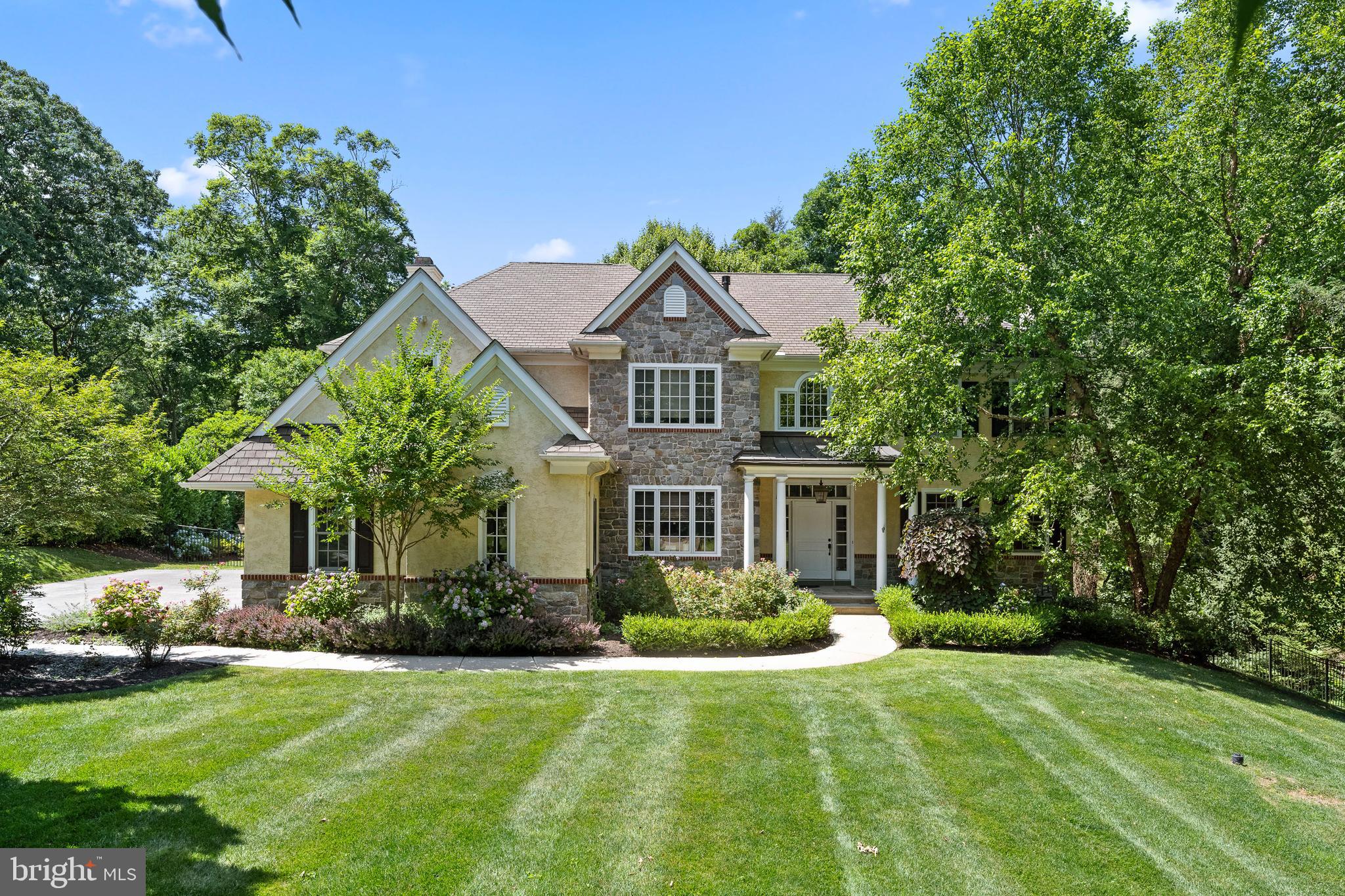 This magnificent grand Main Line family home, designed by award-winning architect Peter Batchelor, sits on a picturesque lot in one of the Main Line’s most sought-after neighborhoods. Offering over 7,800 sq ft of luxurious living space, this handcrafted home boasts 6/7 generously sized bedrooms, 6 full baths, and 1 powder room.
Every detail has been meticulously crafted, from the beautiful stone exterior to the elegant and grandly proportioned interior spaces. The home's open floor plan flows seamlessly, with newly refinished hardwood floors that complement the sophisticated trim and architectural elements throughout. The main level features an impressive foyer with a curved staircase, a large living room with a gas fireplace, and a dining room ideal for hosting guests. Also on the main level is one of two dedicated home offices, providing a perfect space for remote work.
The gourmet kitchen, equipped with a paneled Sub-Zero refrigerator, 36” Wolf range, Thermador wall oven, warming drawer, and quartz countertops, opens to the family room, where coffered ceilings and a gas fireplace enhance the ambiance. Sliding glass doors lead to the rear grounds with a heated pool, which can be maintained with either bromine or chlorine, perfect for year-round enjoyment.
Upstairs, the luxurious primary suite features a gas fireplace, tray ceiling, dual walk-in closets, and a spa-like bathroom with a jetted soaking tub and large shower. Two additional bedrooms are connected by a Jack-and-Jill bath, while the princess suite and guest bedroom each have private en-suite baths. A second home office is located on the third floor, along with a spacious bonus room and full bath, perfect for a game room or additional living space.
The finished walkout lower level offers a second kitchen, bedroom, full bath, living room, and an exercise room, making it ideal for an in-law suite, au pair quarters, or extended guest stay.
The beautifully landscaped front and back yards feature mature trees and flowering plants, all secured by estate fencing and underground electric fencing for pets. This home embodies the pinnacle of modern living, ideally located within walking distance to the charming village of Gladwyne.