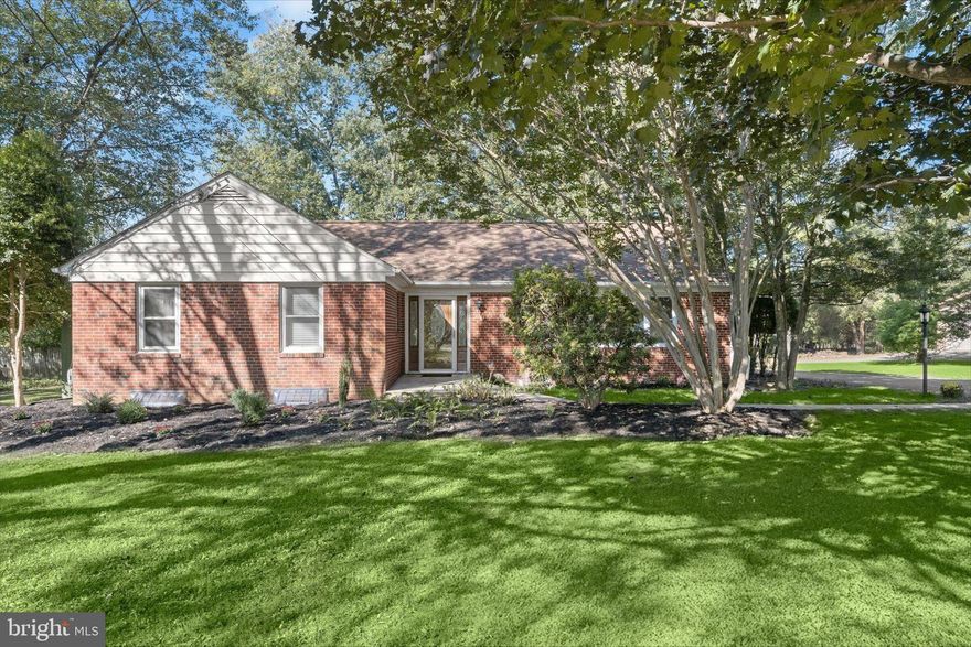 Beautifully renovated brick rancher in Woodstock offering timeless character, modern updates, and exceptional indoor and outdoor living spaces. Mature trees, lush landscaping, and a tranquil pond create a picturesque setting, complemented by a barn with electric, a detached garage, and dual driveways for added convenience and ample parking.  Inside, the home has been thoughtfully refreshed with fresh paint, refinished hardwood floors, new carpet, and updated lighting throughout. The foyer opens to a spacious living room featuring a wood stove insert and a stunning picture window that floods the space with natural light. The adjoining dining room showcases charming built-in corner cabinets and flows seamlessly into the renovated kitchen, complete with inset cabinetry, granite countertops, and stainless steel appliances including a double oven.  A true showpiece, the expansive three-season sunroom offers a cathedral ceiling, corner wood-burning stove, and walls of windows overlooking the serene property. Recently updated with new tile flooring, exterior siding, and a peaked roof, this space creates a seamless connection between the home and its natural surroundings.  The main level features three bedrooms, including a primary suite with an en-suite bath highlighted by a tiled soaking tub and shower surround. Two additional bedrooms share a second full bath with a frameless glass shower. Both full bathrooms are enhanced with heated floors for year-round comfort.  The finished lower level extends the living space with a large recreation room featuring a wet bar and full-length bar seating, a versatile bonus room, and a convenient half bath. The utility room includes laundry, ample storage, and a separate entrance from the sunroom. A floored walk-up attic with stair access provides additional storage and functionality.  Set on 1.39 acres across two parcels, including a 1.03-acre main lot and an additional .36-acre parcel referenced on the deed, this property offers space, privacy, and flexibility. Outdoor living shines with multiple paver patios, a fire pit, a pond accented by a charming bridge leading to a lower patio, mature landscaping, a flourishing garden, and a berry patch for homegrown enjoyment. The rear adjacent property is permanently protected and cannot be built upon, enhancing privacy and tranquility.  The detached garage accommodates four or more vehicles and is currently used as an exercise room, while the barn provides additional storage and workspace with electric, lighting, and fans. Ideally located, this home offers the perfect blend of peaceful, semi-rural living with convenient access to outdoor recreation at the Howard County Conservancy and Patapsco Valley State Park, as well as nearby amenities and major commuter routes including I-70, Route 40, and Route 29.  A rare opportunity combining serenity, functionality, and modern style in a coveted Woodstock setting.