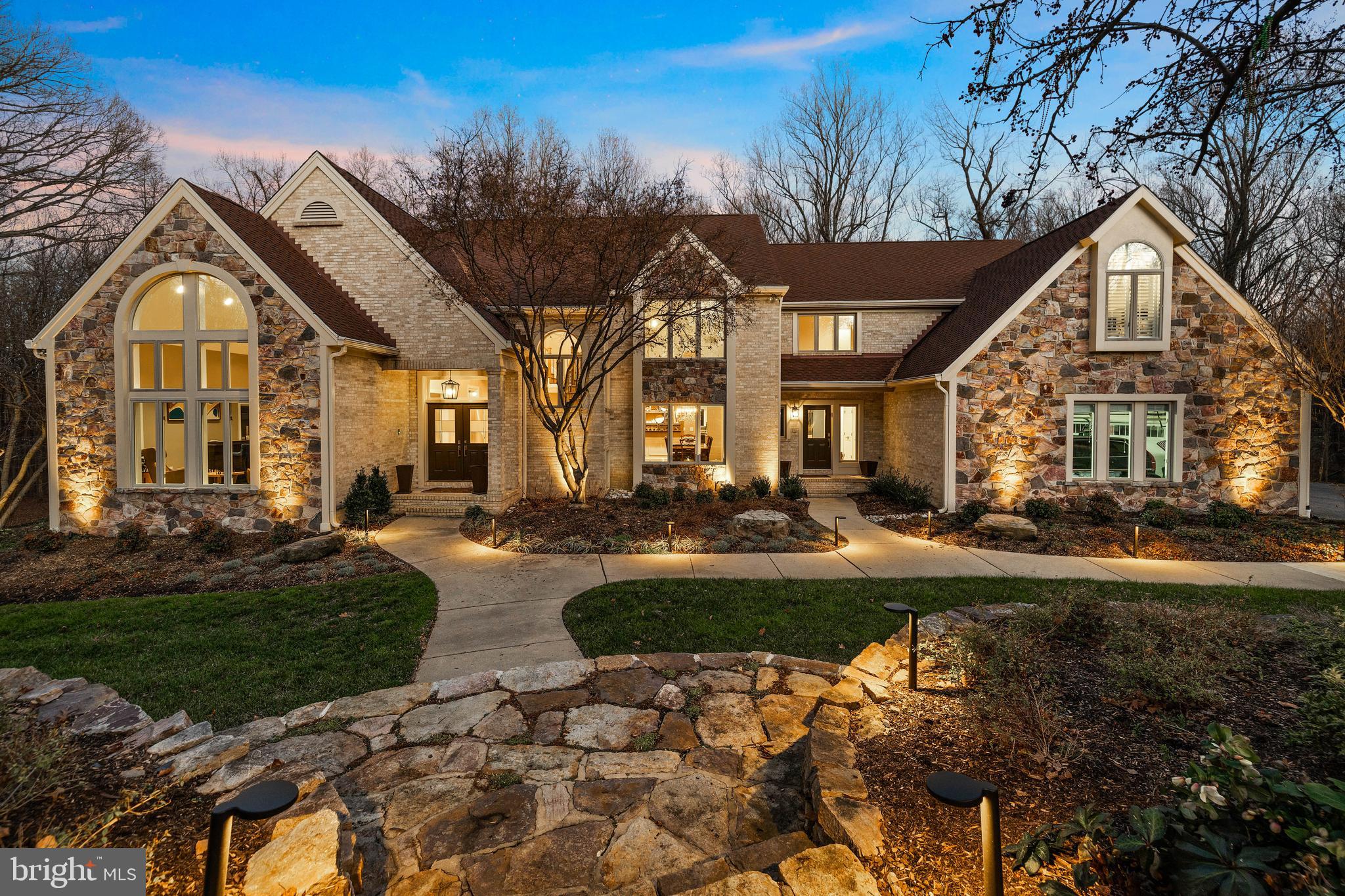 The tree-lined driveway culminates at this statuesque custom-built stone-and-brick home, encircled by mature trees that immerse this property in both privacy and natural beauty. The 4+ acre lot immediately impresses with gorgeous hardscape featuring new lighted stone steps, walkways and professionally styled landscaped beds plus abundant outdoor living options, which features a new expansive composite deck and balcony, raised-bed garden area, stone firepit in an open field surrounded by the woods and custom LED lighting. The piece de resistance - a heated pool that boasts a new al-fresco grill/ kitchen center and multiple seating areas. The newly invigorated "Smart Home" interior includes custom metal-and-oak foyer balustrade, hardwood floors, a reinvented and expanded wet bar, a media room and so much more! The spacious Owners' Suite offers both a sitting room/office AND exercise/bonus room plus luxury bath; the expansive eat-in kitchen opens to a large family room with fireplace; the newly renovated lower level features a media room, renovated baths including a sauna and a rec room with an impressively appointed wet bar. This special sanctuary is perfect for whatever revelry or respite you are seeking!