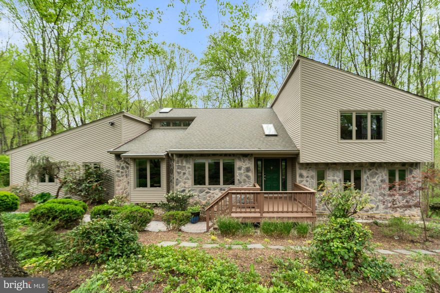 This modern contemporary Vienna home offers a perfect blend of style, functionality, and natural beauty. Thoughtfully designed across three levels, it features 5 bedrooms, 4 bathrooms, and 3,244 finished square feet of living space. Situated on a stunning 1.15 acre lot on a quiet cul-de-sac, the property is surrounded by mature woodlands and a flowing creek. The main level features an open floor plan with a formal living room and dining room, ideal for entertaining. The expansive family room centers around a gas fireplace with built-ins and a dry bar, while the adjoining gourmet kitchen, featuring top of the line appliances, and breakfast room flow seamlessly together. A main level bedroom is currently configured as a two person office with built-ins, providing a perfect setup for remote work. Upstairs, the primary suite includes a private seating area and a sliding glass door opening to a serene balcony with treetop views. Two additional bedrooms and a full bath complete the upper level. The walk-out basement features a recreation room, custom built-in shelving, wet bar, full bath, storage room, and a fifth bedroom suite with full size windows, currently configured as a bright and airy studio. Entertain outside on a three level deck and patio equipped with a built-in natural gas grill and an upper level fire pit connection. The integrated Bose SoundTouch multi-room speaker system, including deck coverage, enhances both indoor and outdoor gatherings. Additional highlights include a two-car garage with natural light, built-in cabinet storage, and a 60-amp 240V level-2 car charger—perfect for EV owners. Located just steps from the 45 mile W&OD bike path and the breathtaking 100+ acre Meadowlark Gardens, this home also offers a convenient commute to Reston, Tysons, Arlington and DC, balancing tranquility and accessibility in one remarkable package. All this and with-in the top rated Marshall Pyramid.